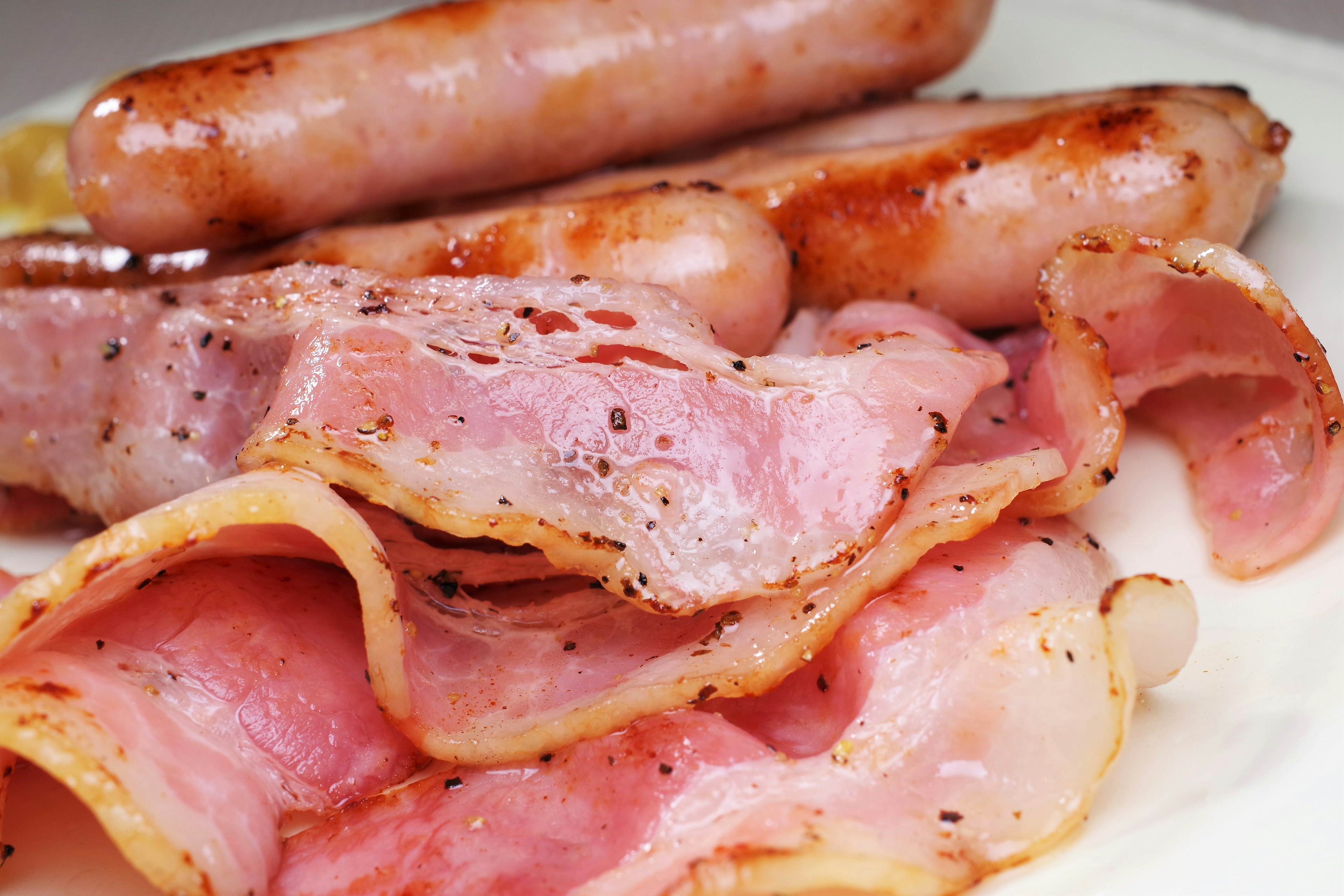 Platter of crispy bacon and grilled sausages