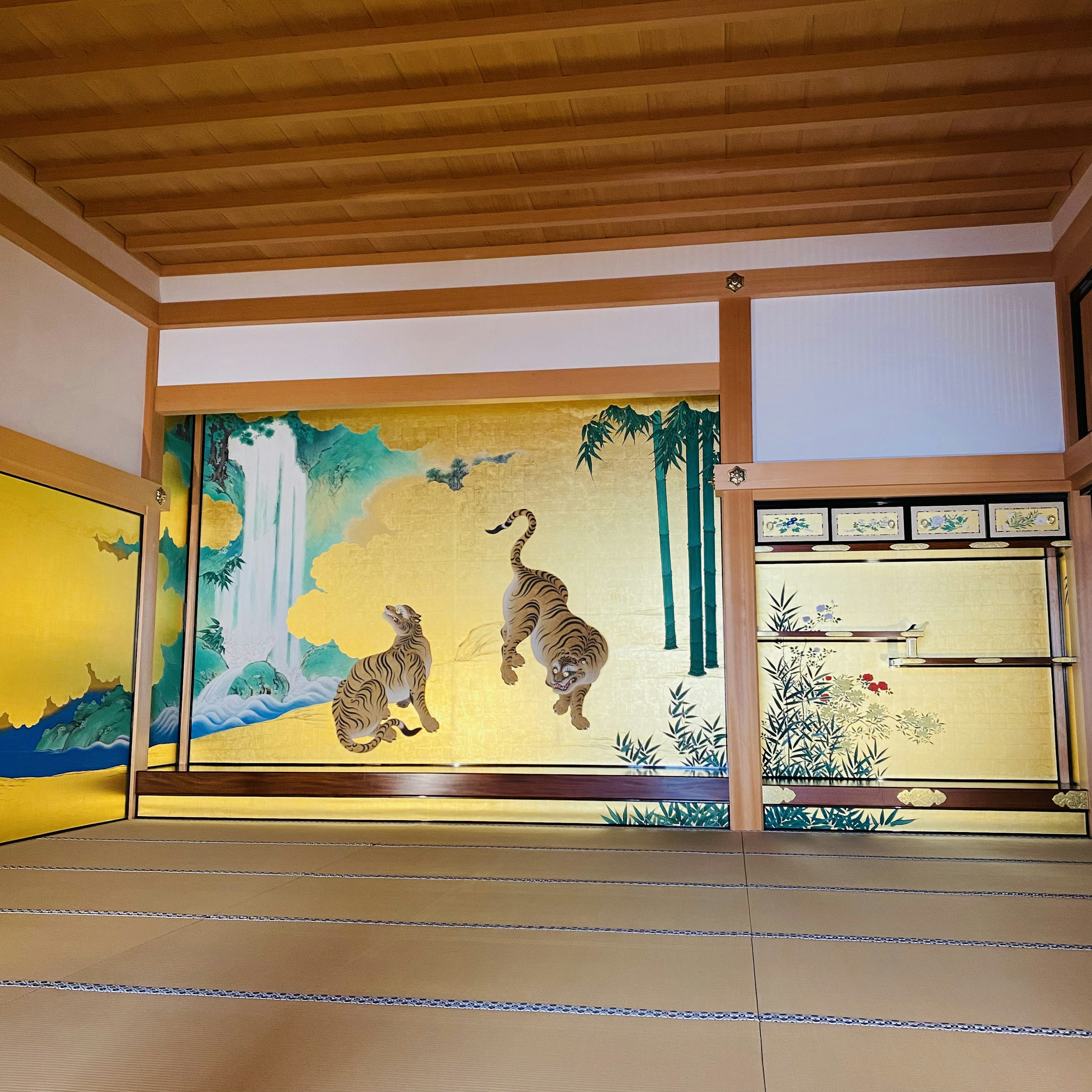 Habitación japonesa con pintura mural de dos gatos y una cascada