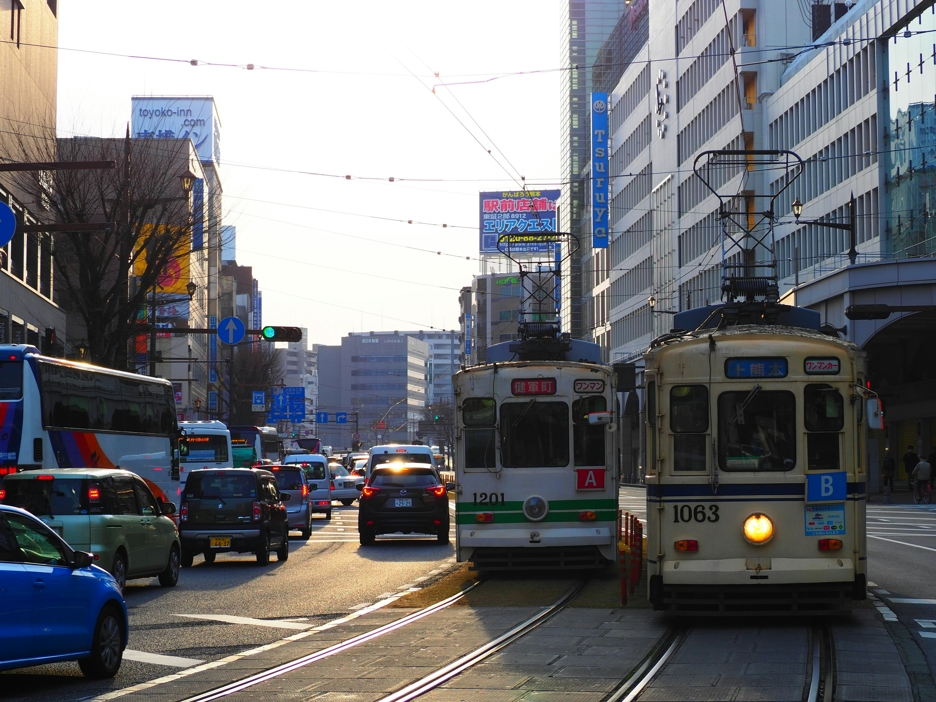 A busy street scene featuring trams and cars in an urban setting