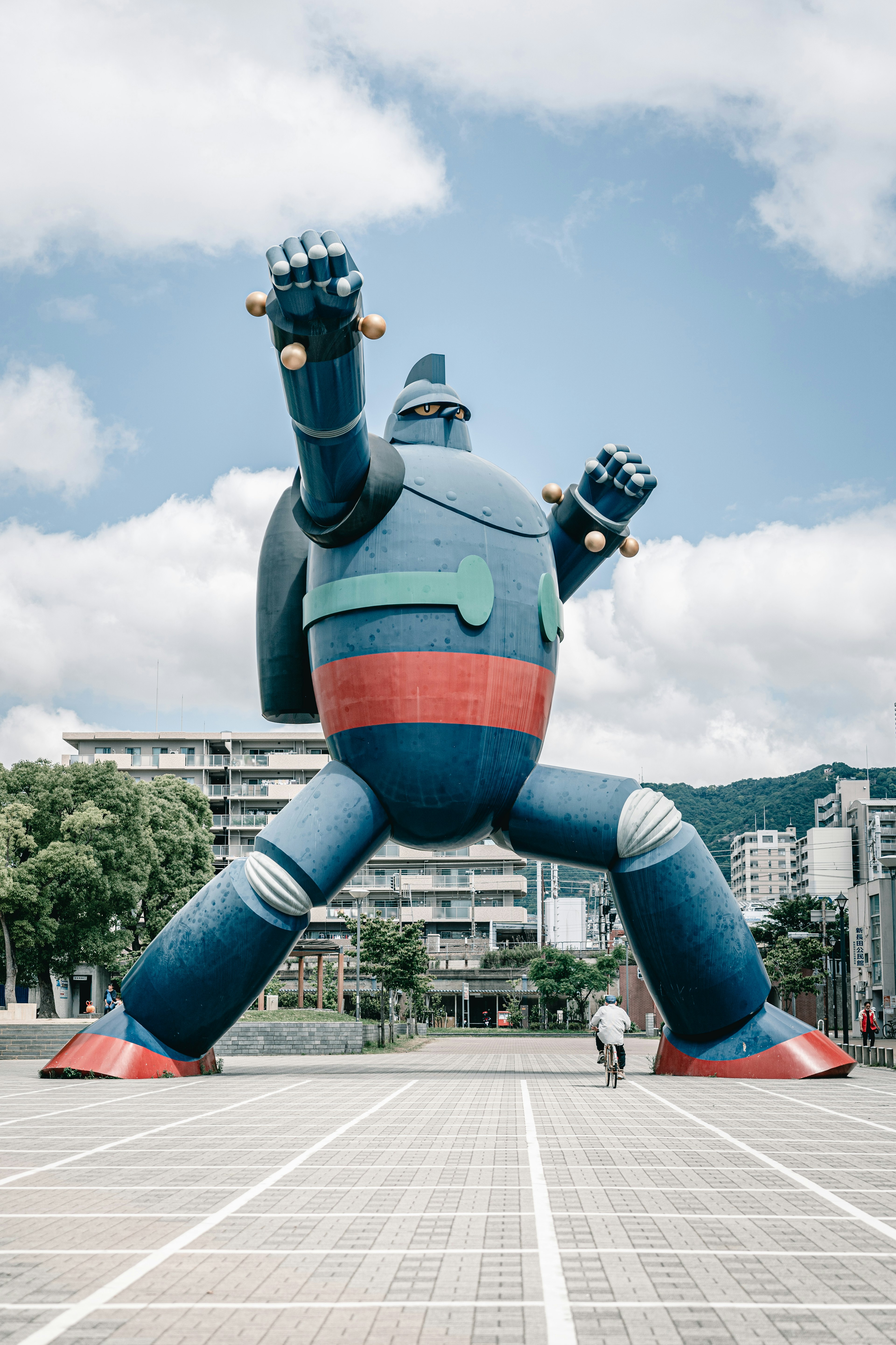 Une grande statue de robot se dresse dans une place ouverte