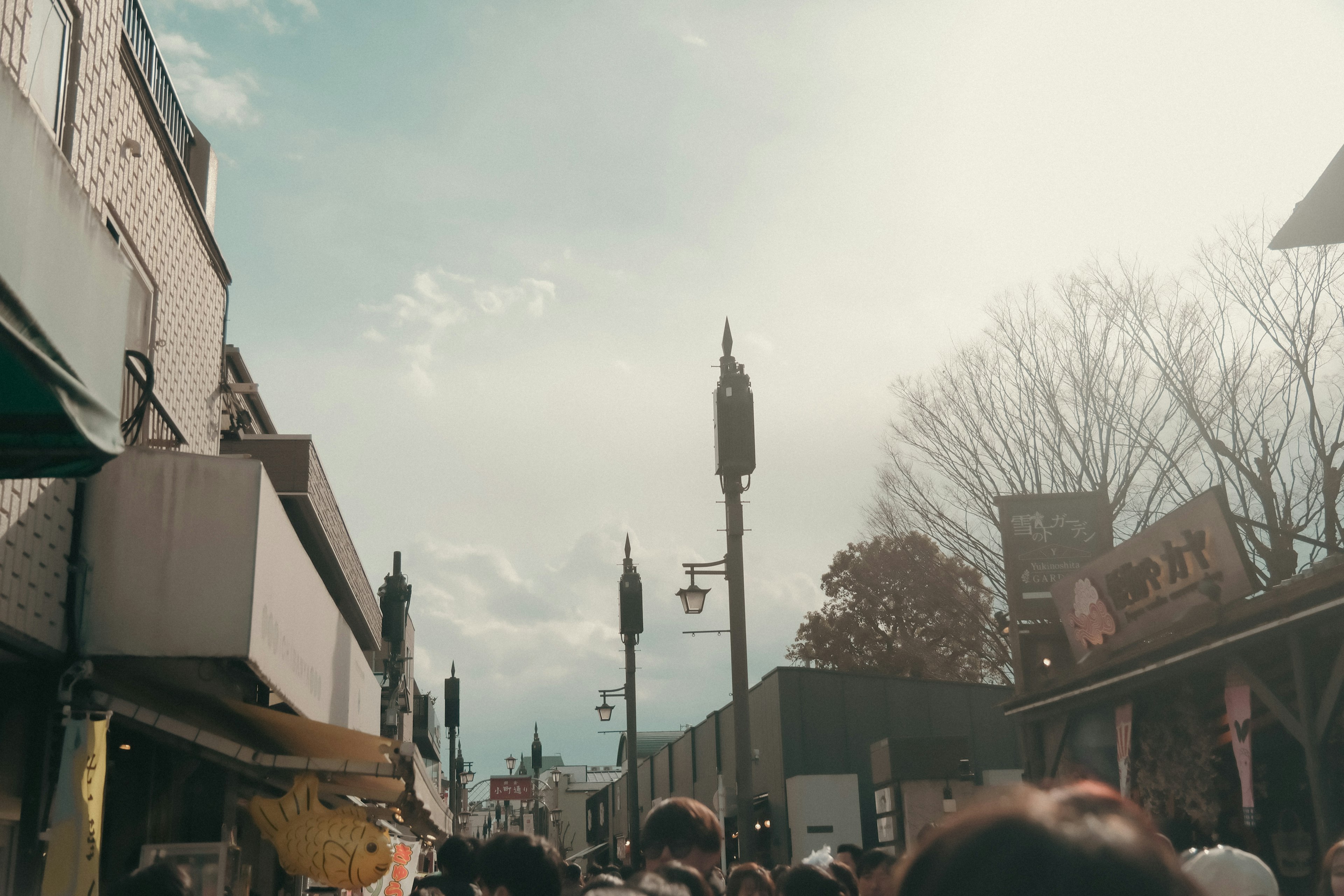 Escena de calle concurrida con personas y cielo azul