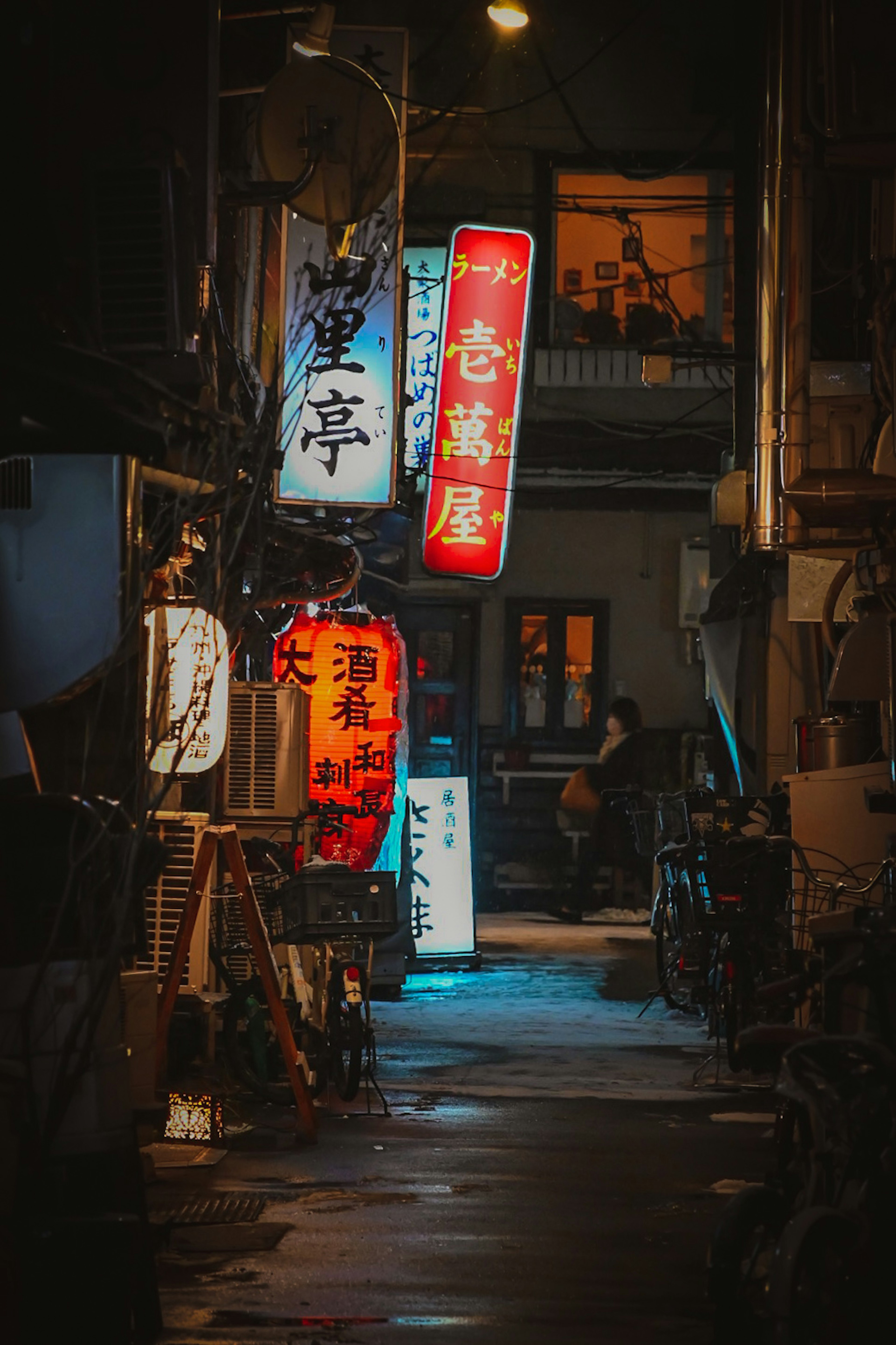 夜の街路にある色とりどりの看板が輝く狭い路地