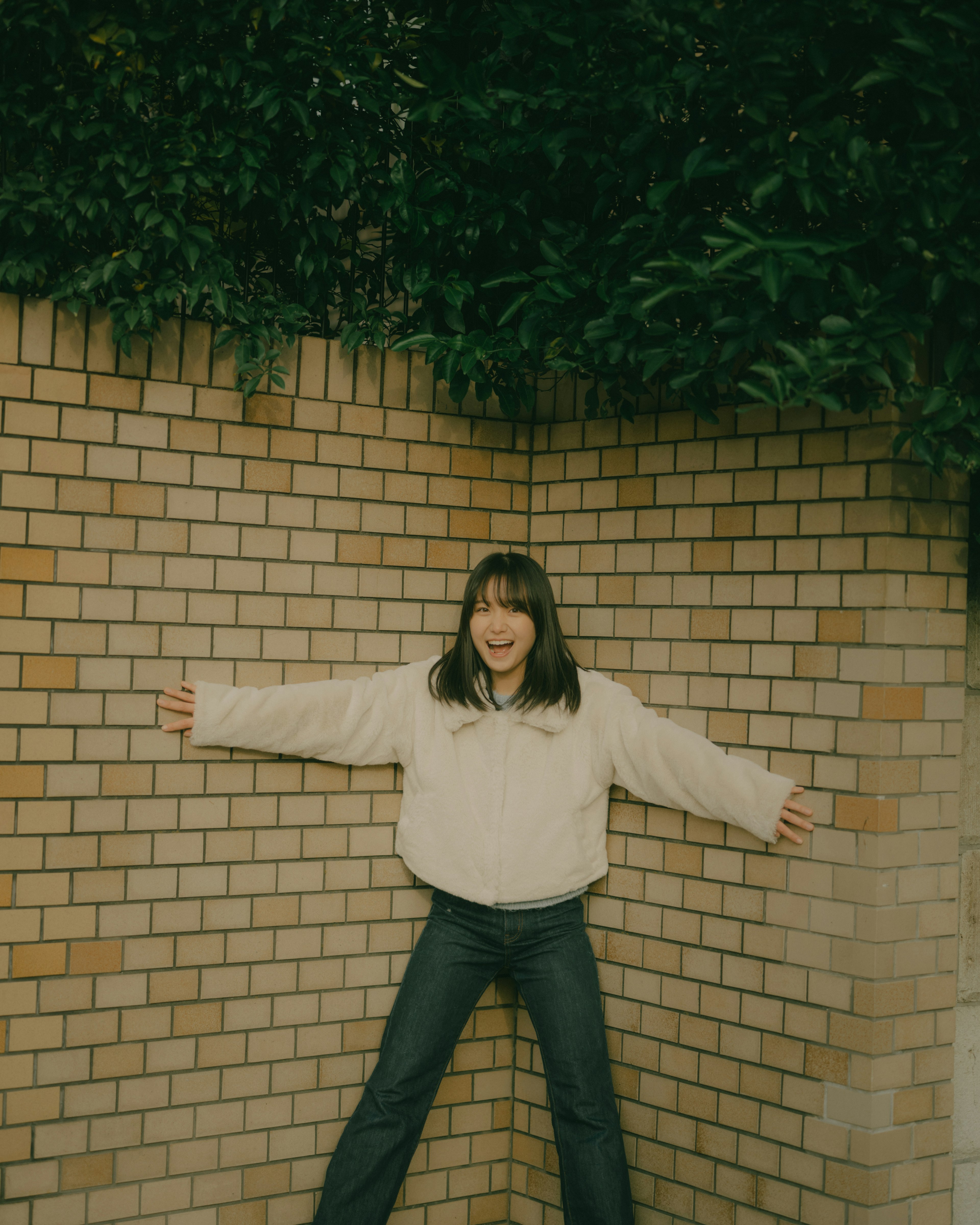 Smiling woman standing against a brick wall