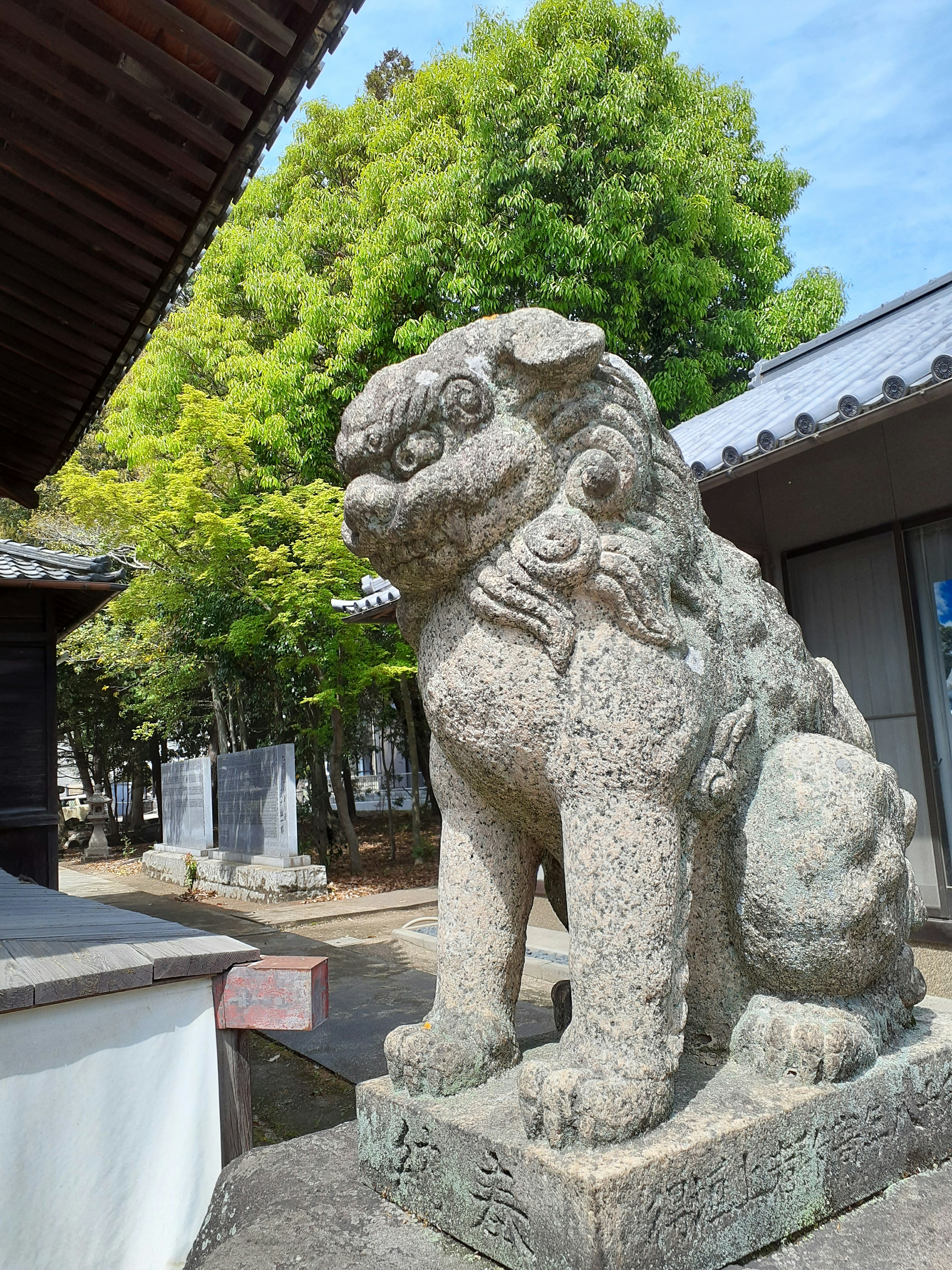 Stone guardian lion statue standing under a blue sky