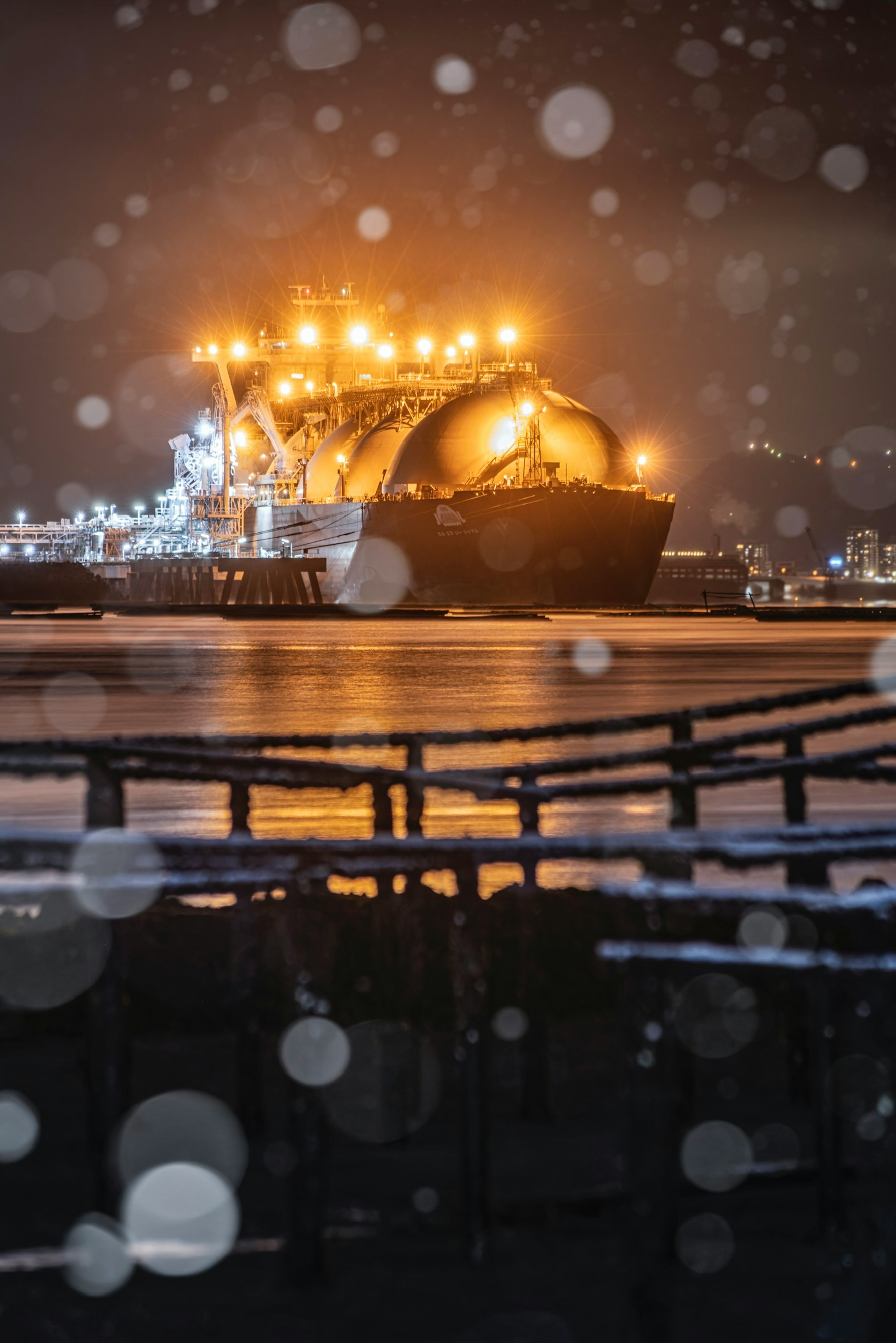 Grande nave cisterna illuminata nella neve con il paesaggio circostante