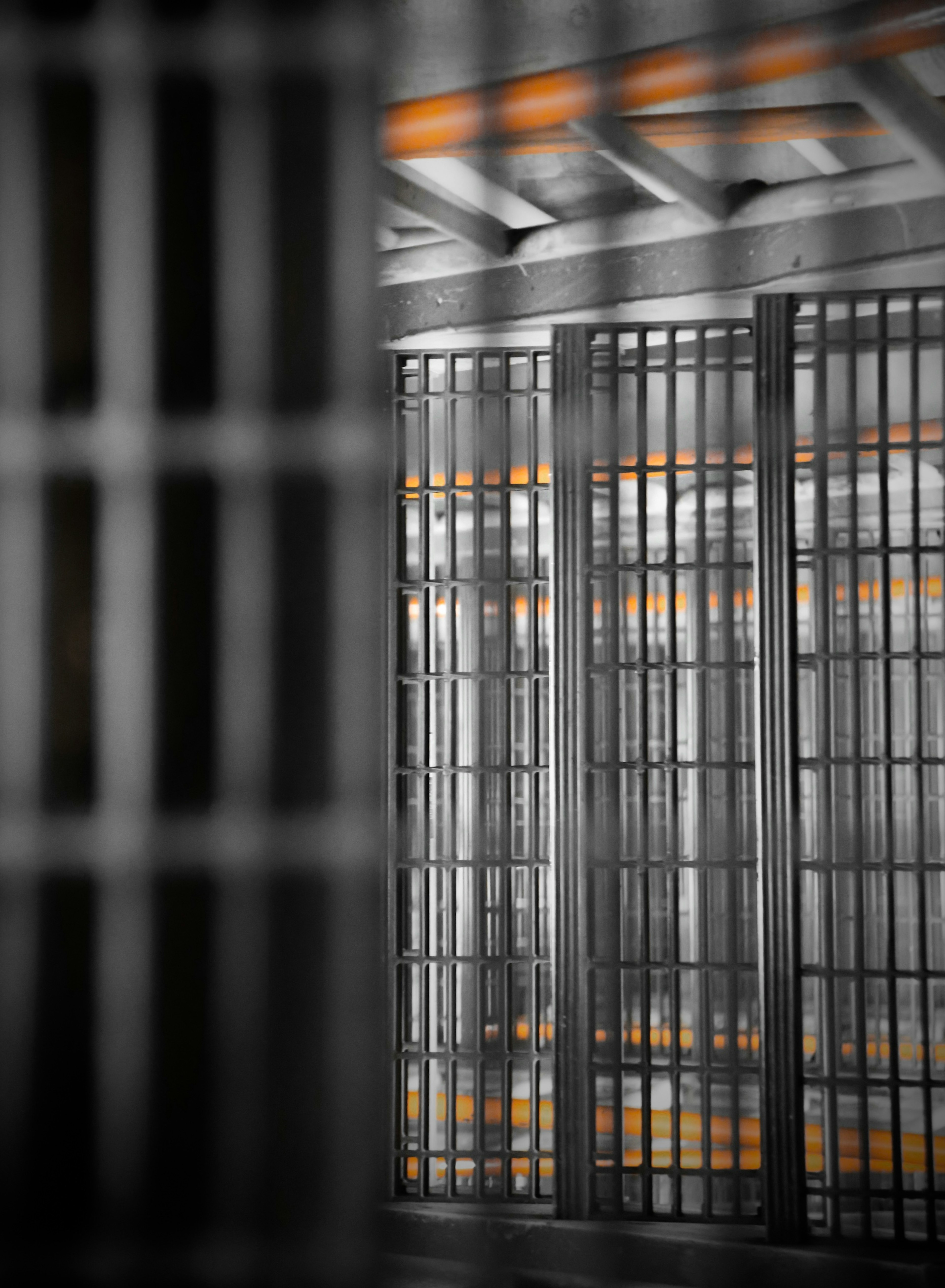 Grid-patterned doors with bright orange light in a black and white setting