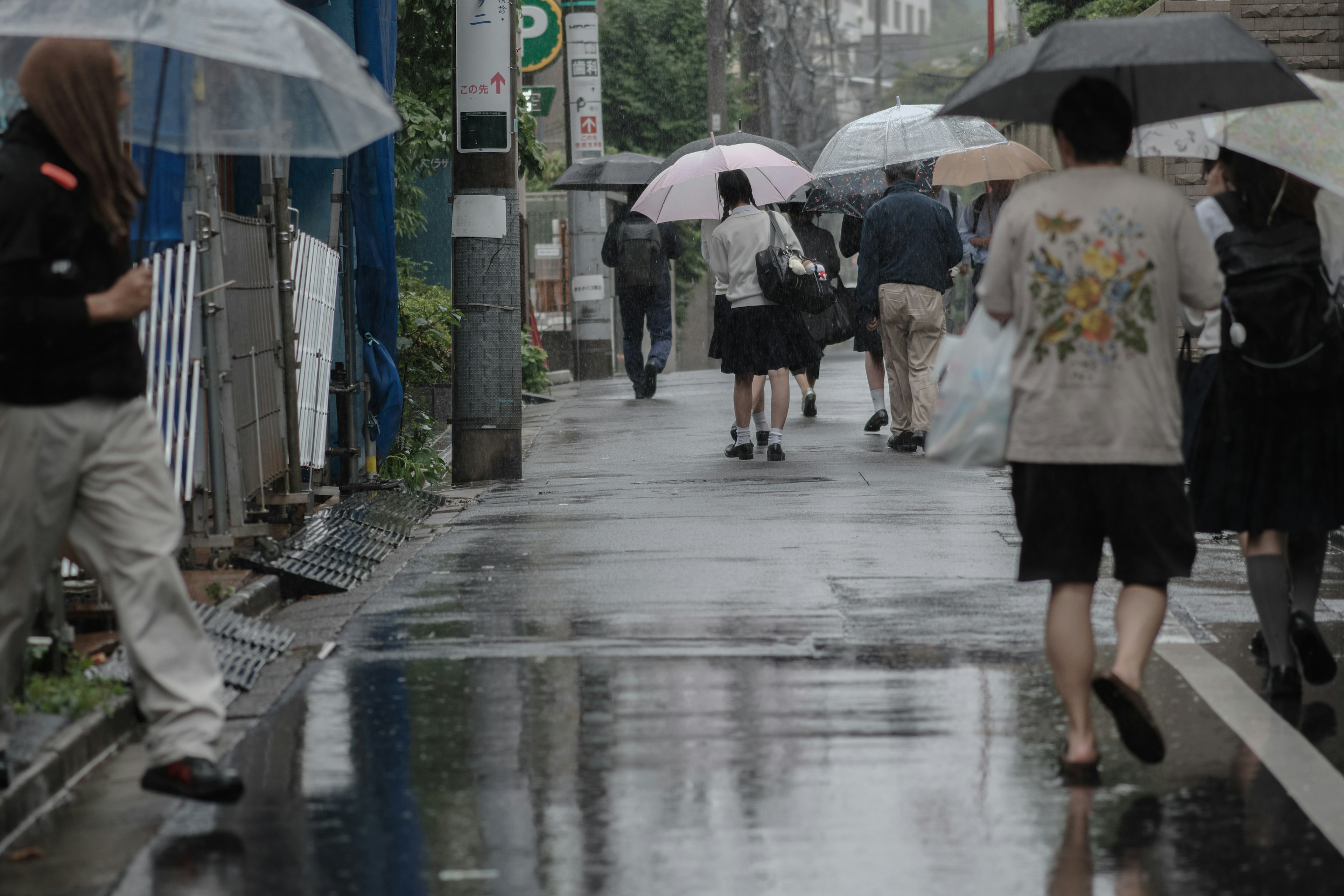 在雨中撐著傘走的人們