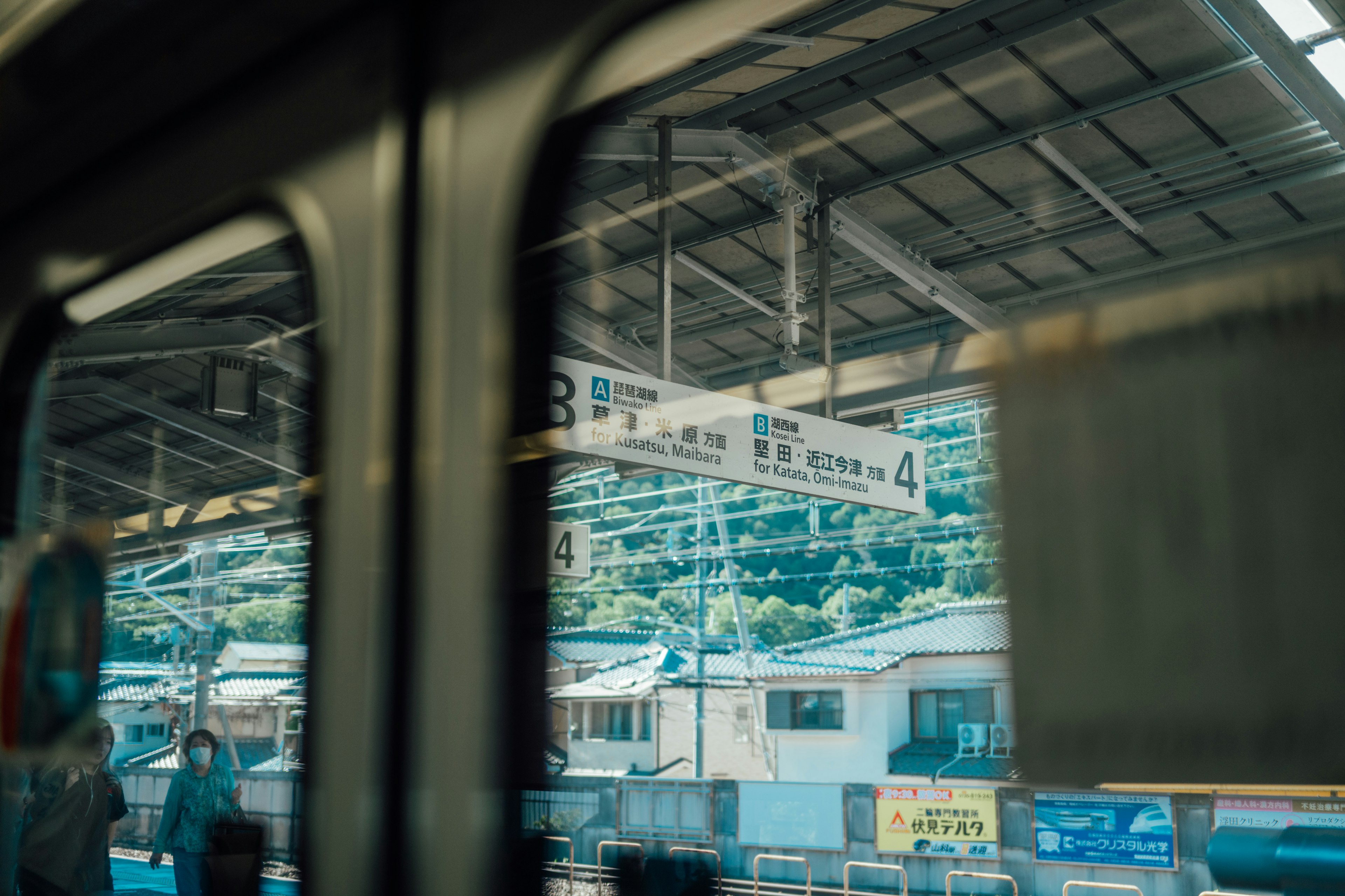 Pemandangan papan stasiun dan pemandangan sekitar melalui jendela