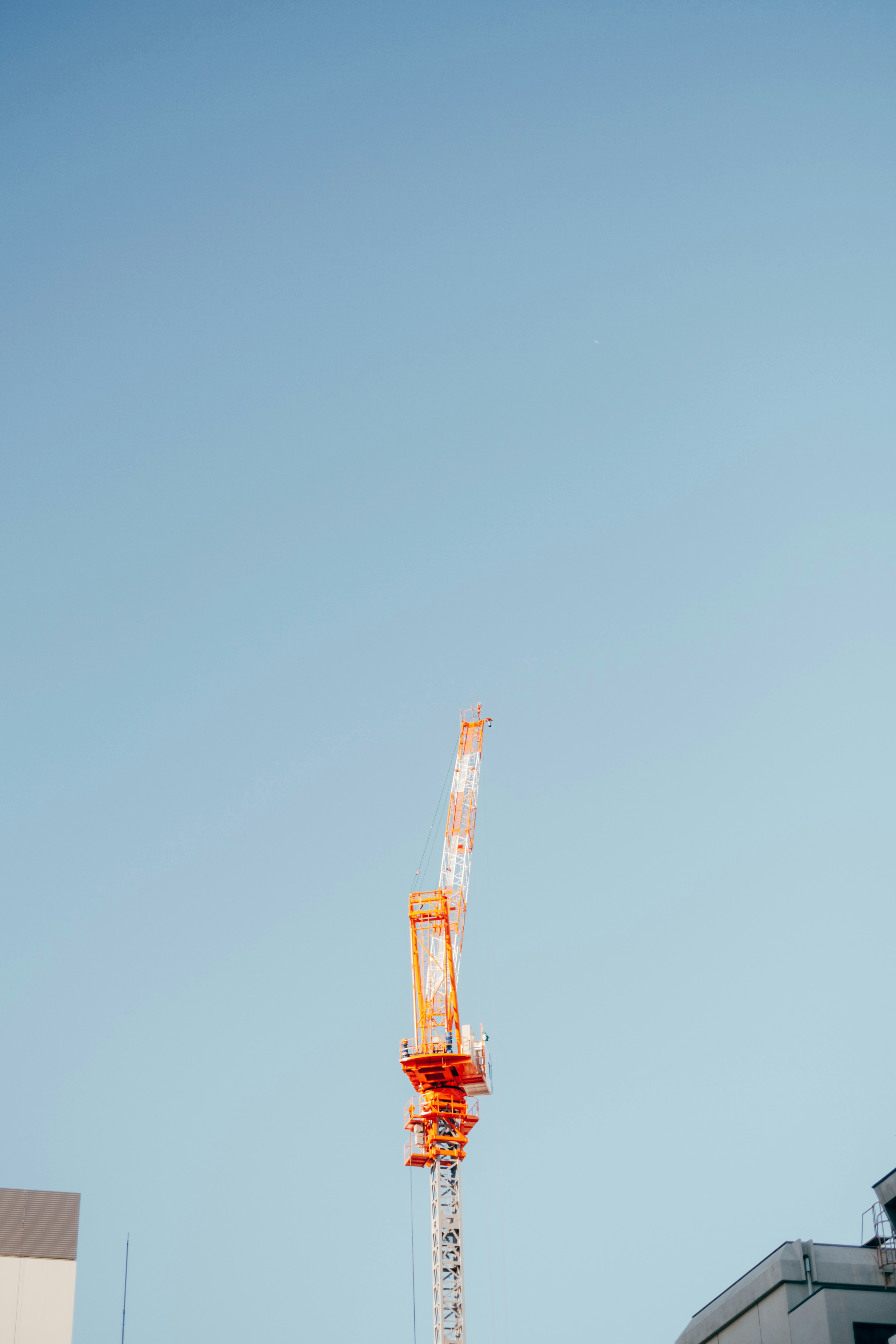 Orange Kran vor einem klaren blauen Himmel