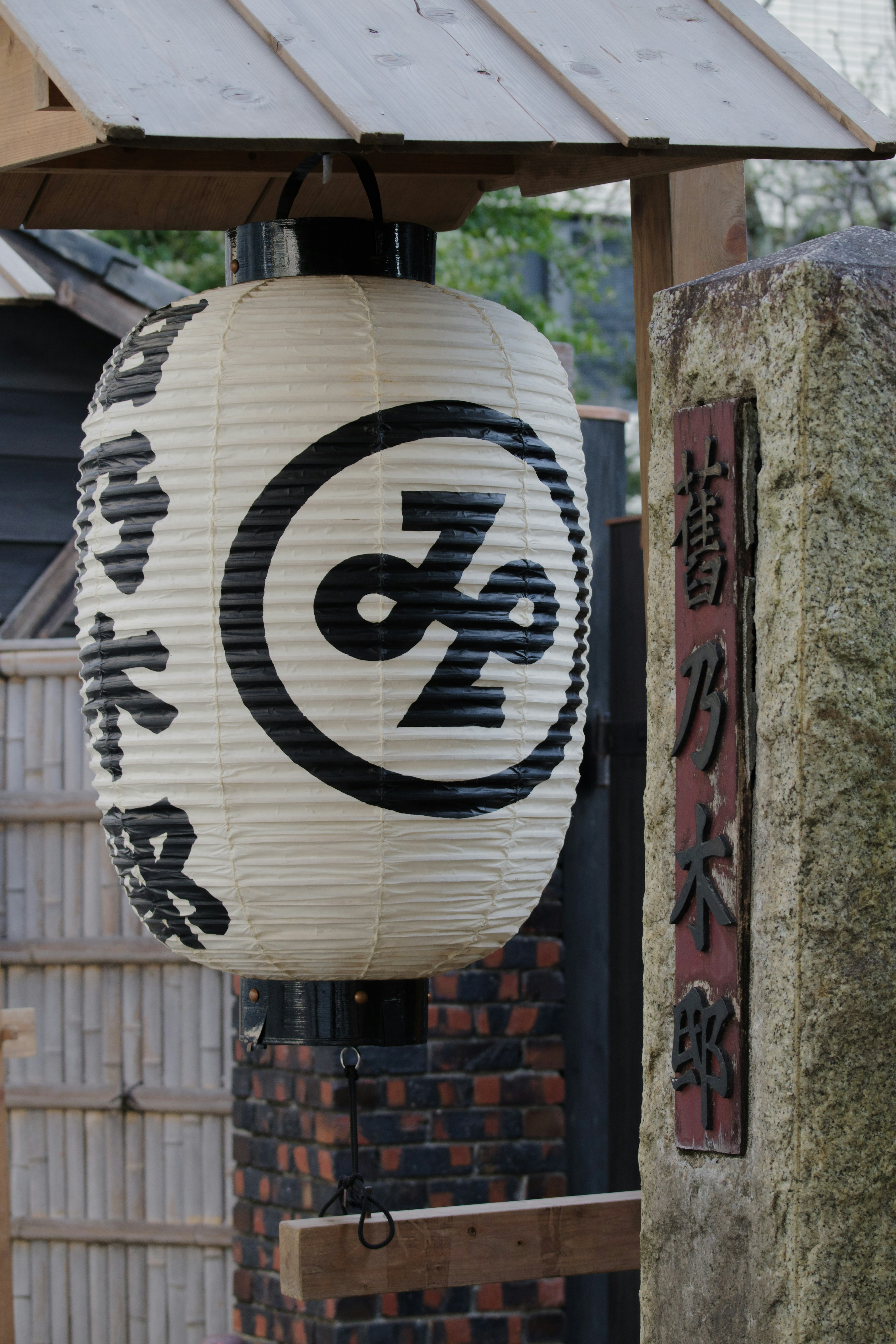 Lampion tradisional Jepang dengan karakter hitam dan simbol di latar belakang putih