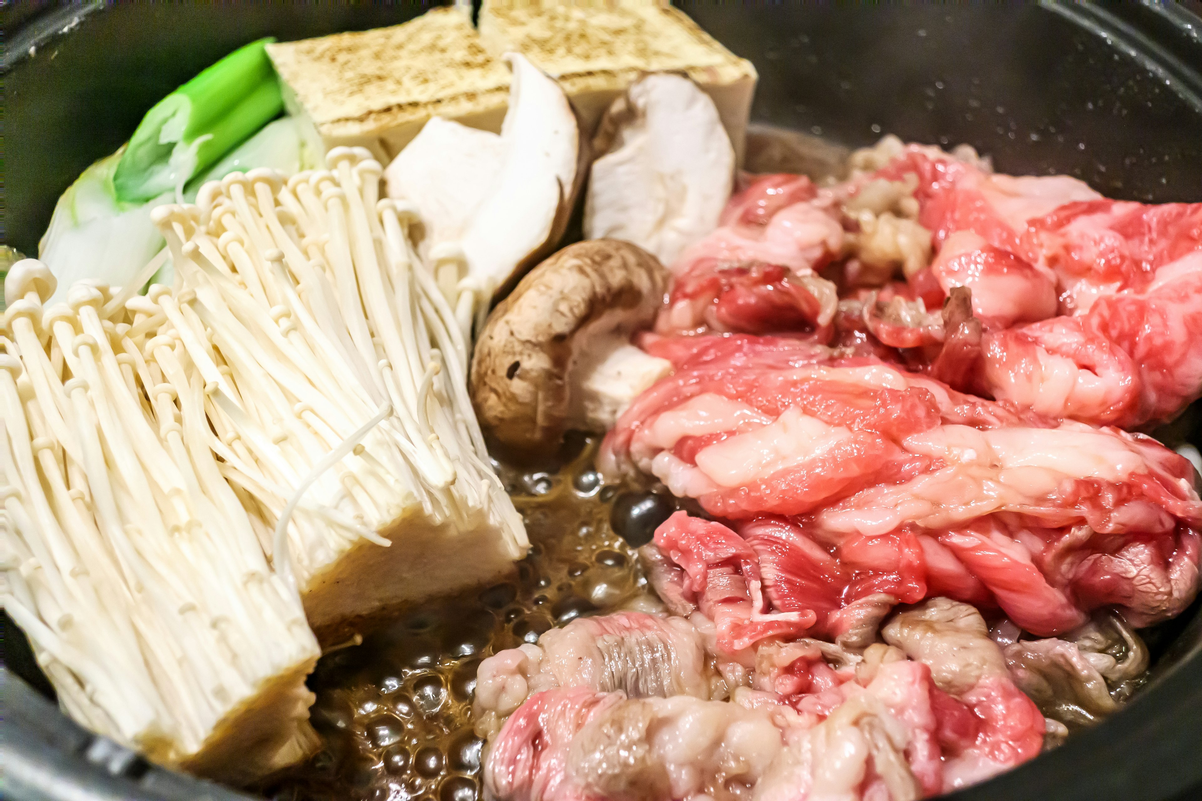 鍋料理の具材としての肉、きのこ、豆腐、野菜が入った鍋