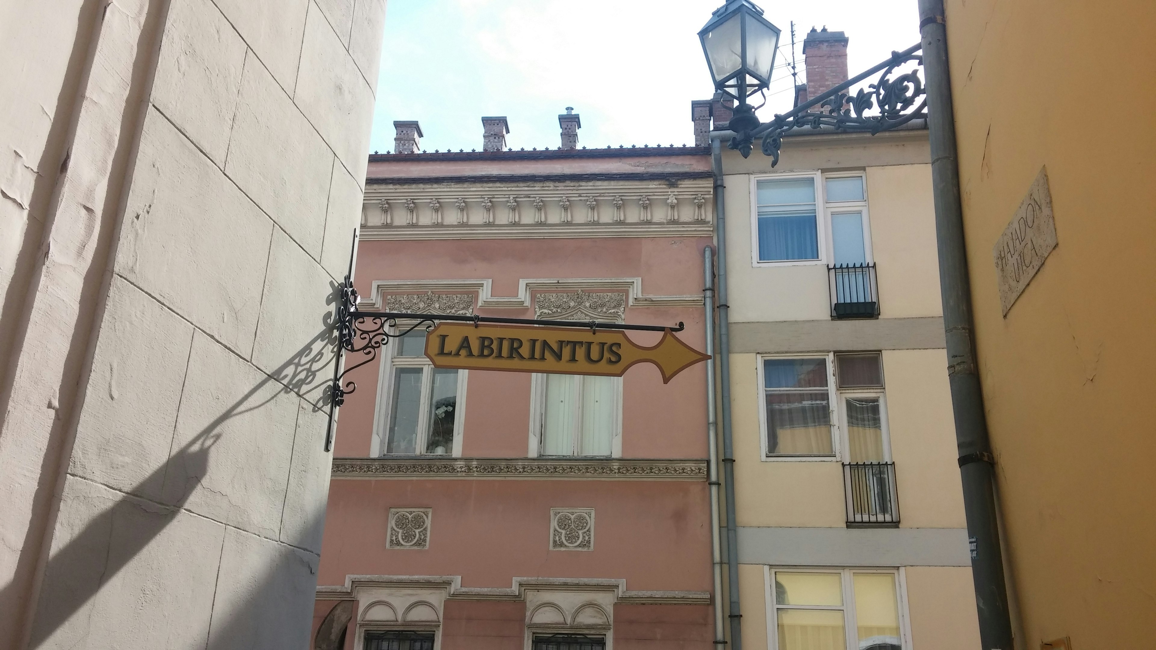 Narrow street sign for Laurentus with colorful buildings