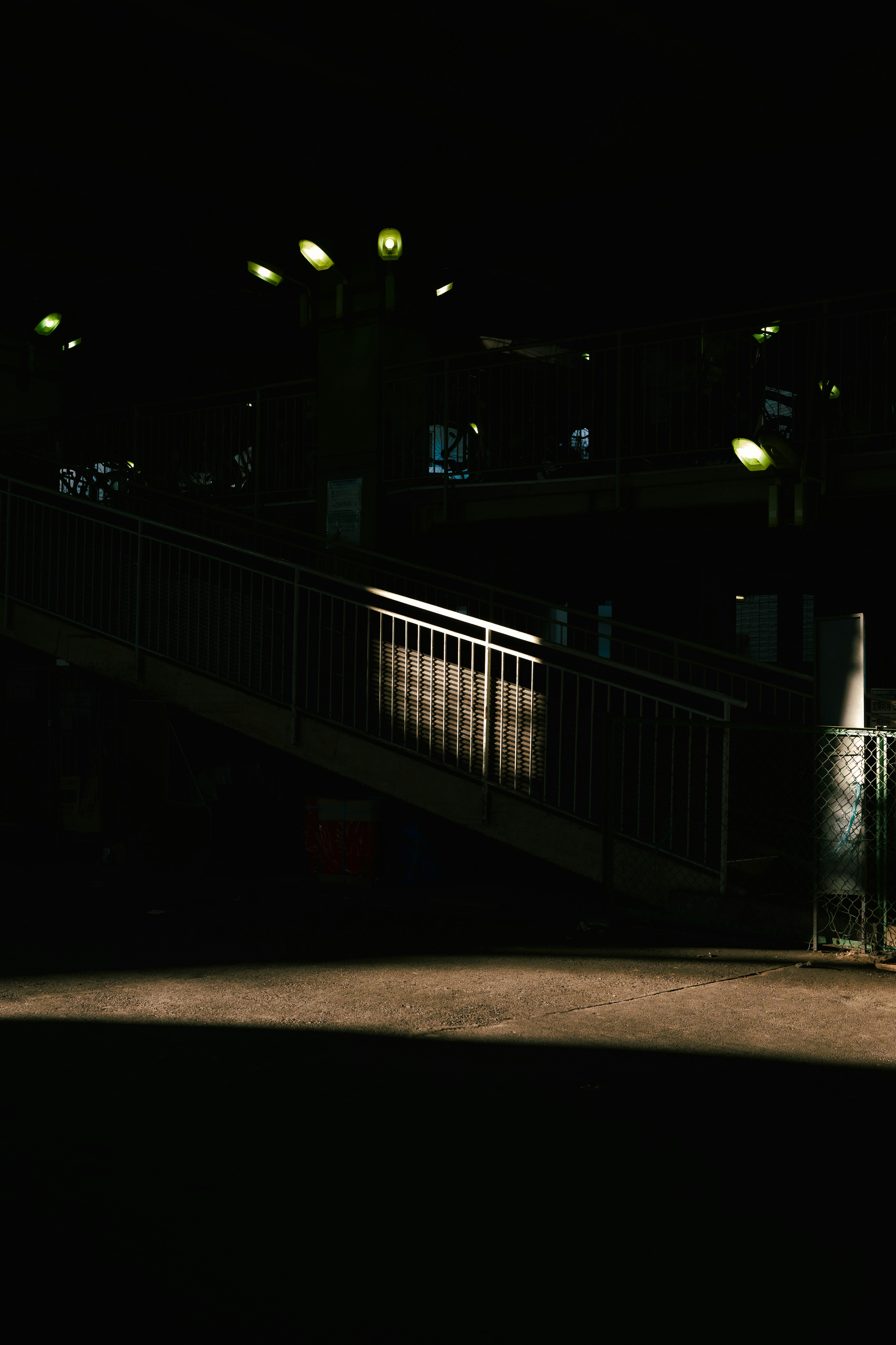 A dimly lit scene featuring stairs and striking lighting effects