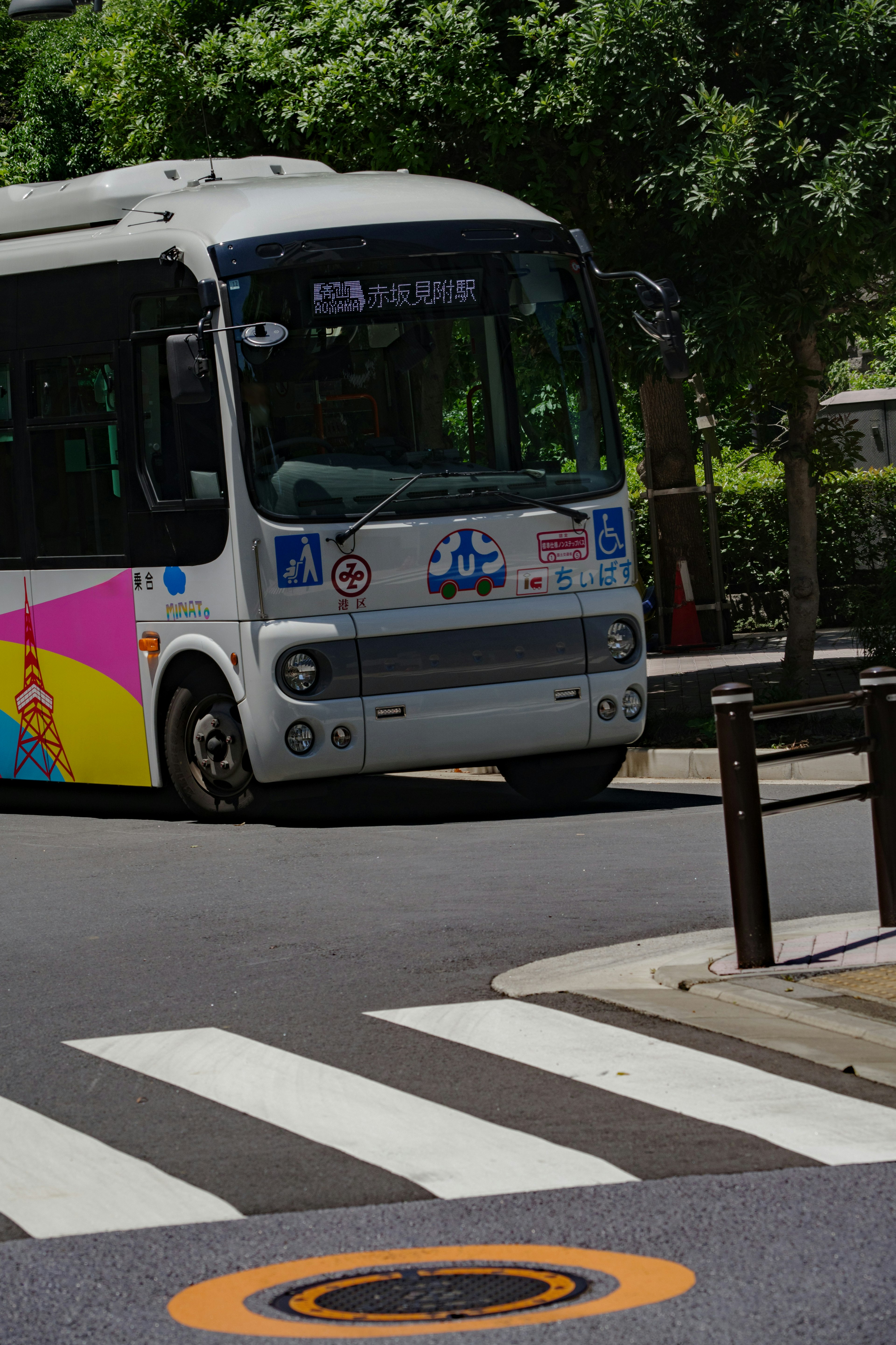 Colorful bus passing over a crosswalk in an urban setting