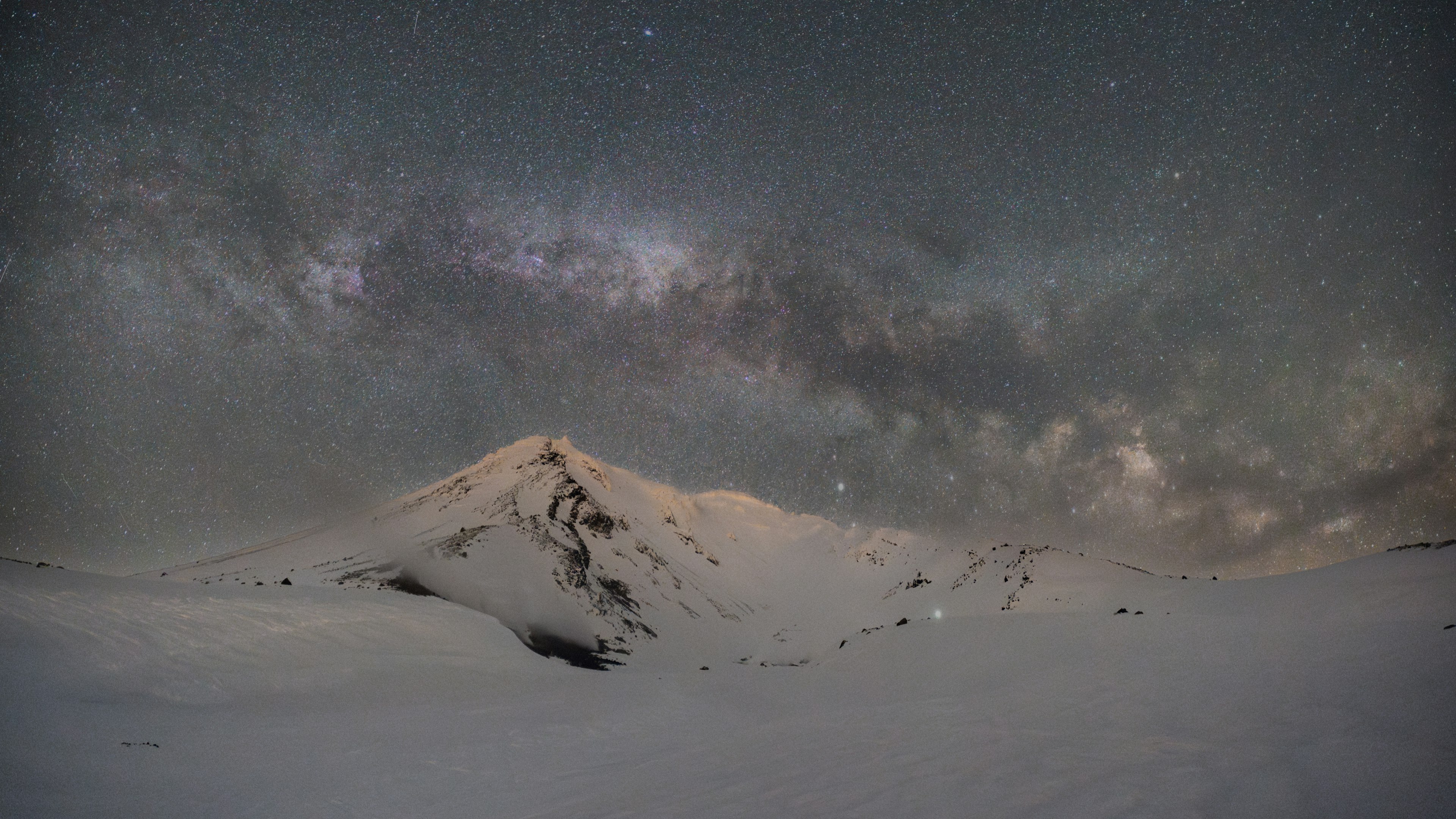 Montaña cubierta de nieve bajo un hermoso cielo estrellado