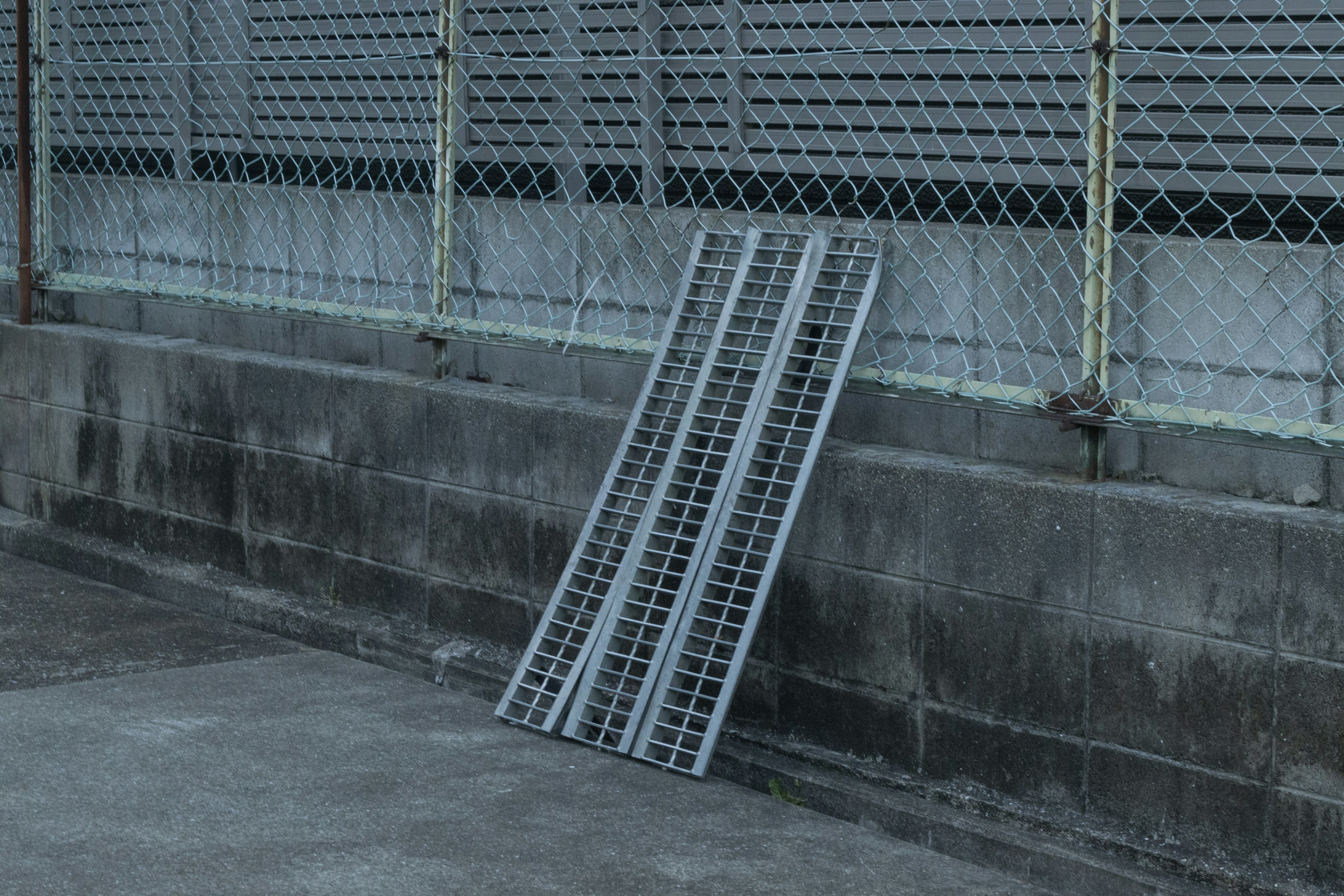 Pallet in metallo grigio appoggiato a un muro di cemento