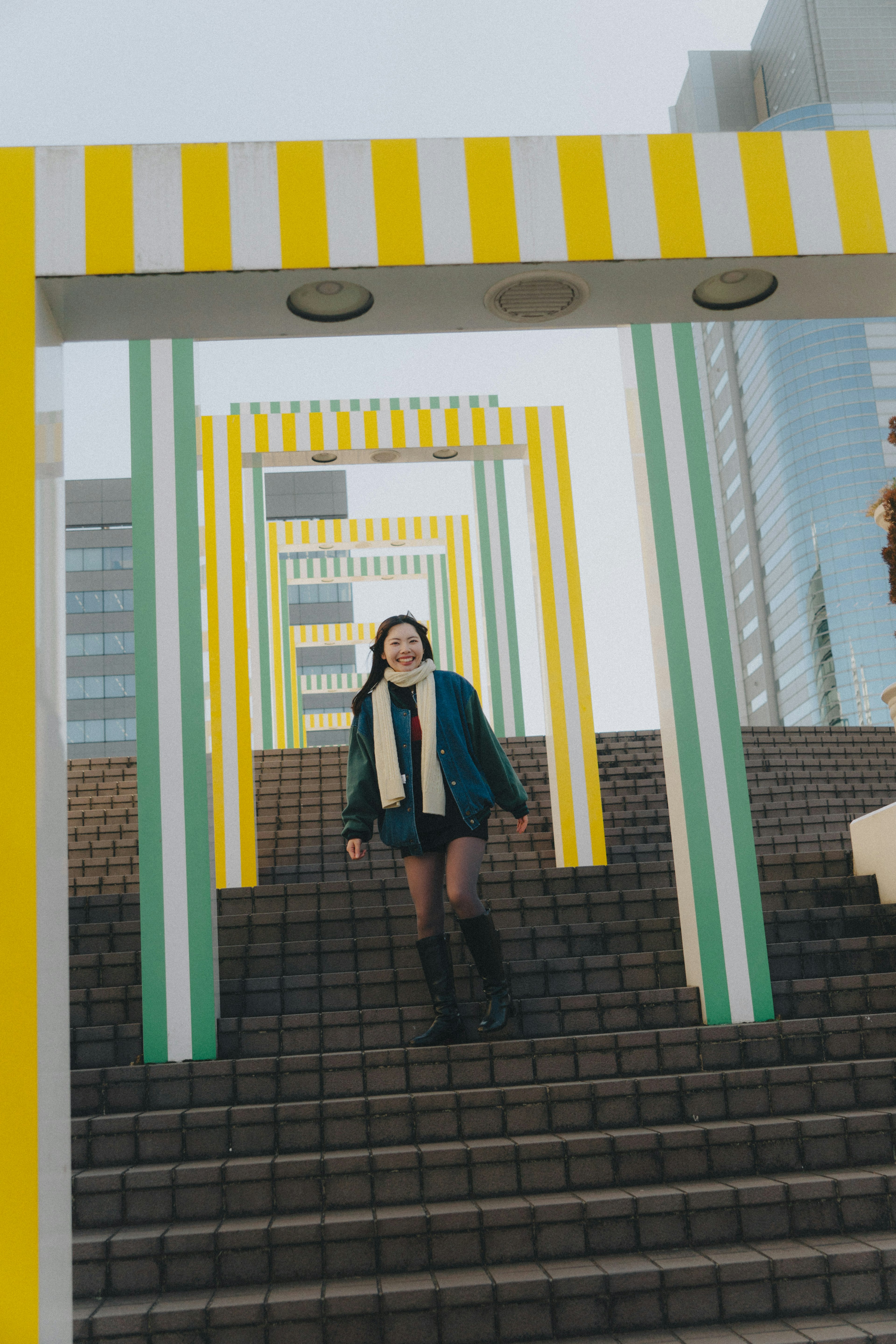 A woman walking through colorful arches on stairs