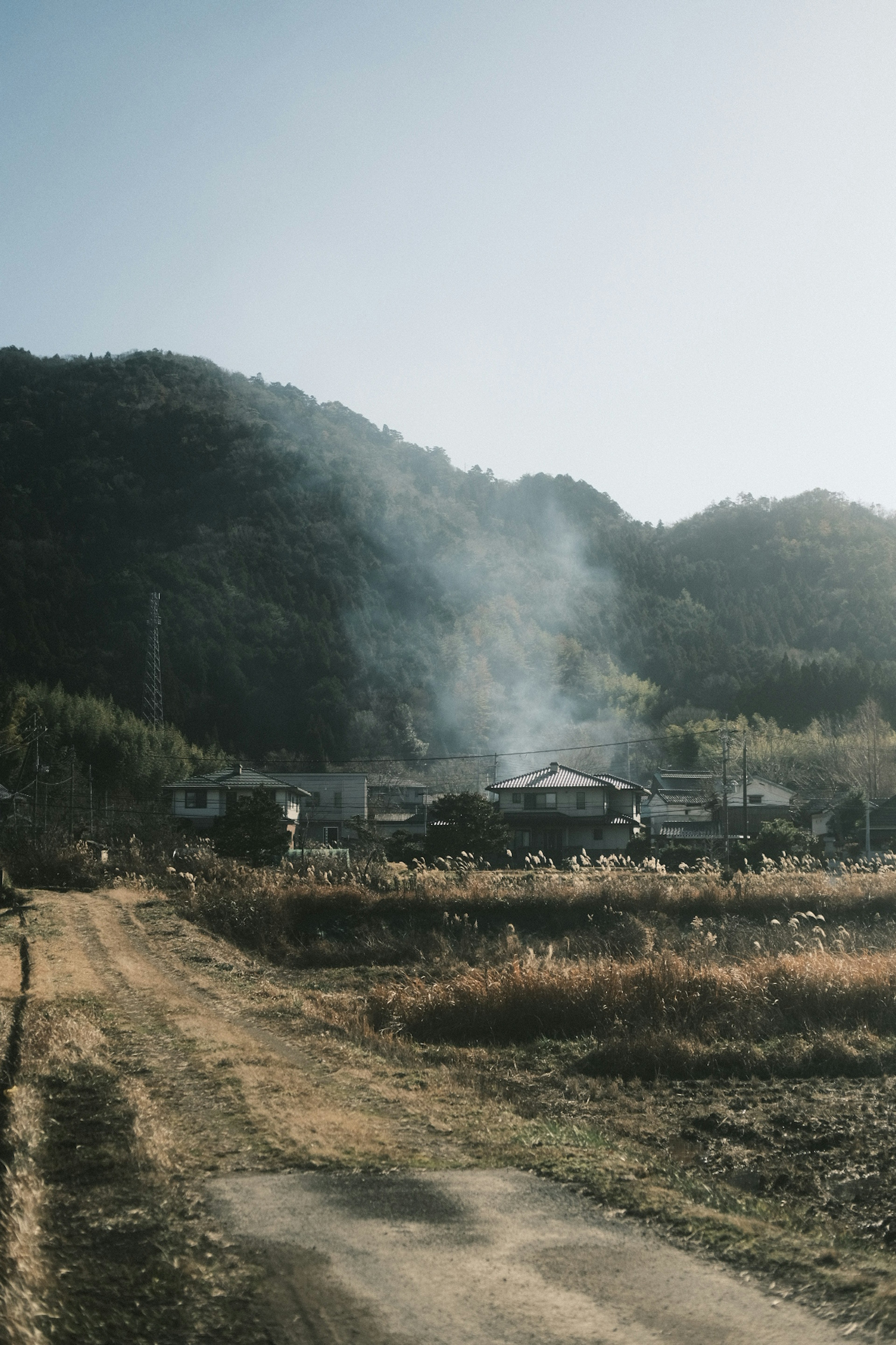 산속의 마을에서 연기가 피어오르는 농촌 풍경