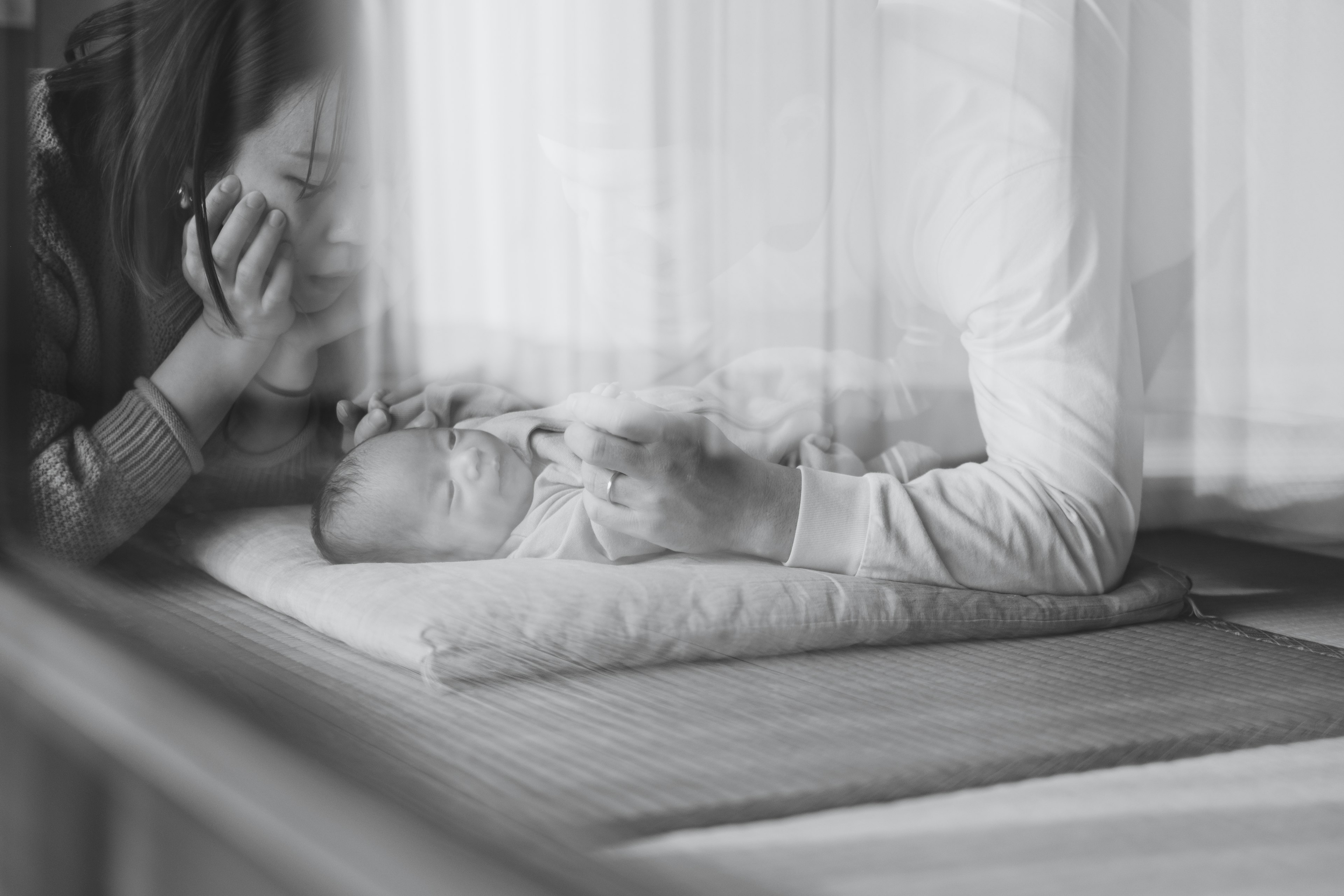 Foto en blanco y negro que captura un momento íntimo entre un bebé y una madre