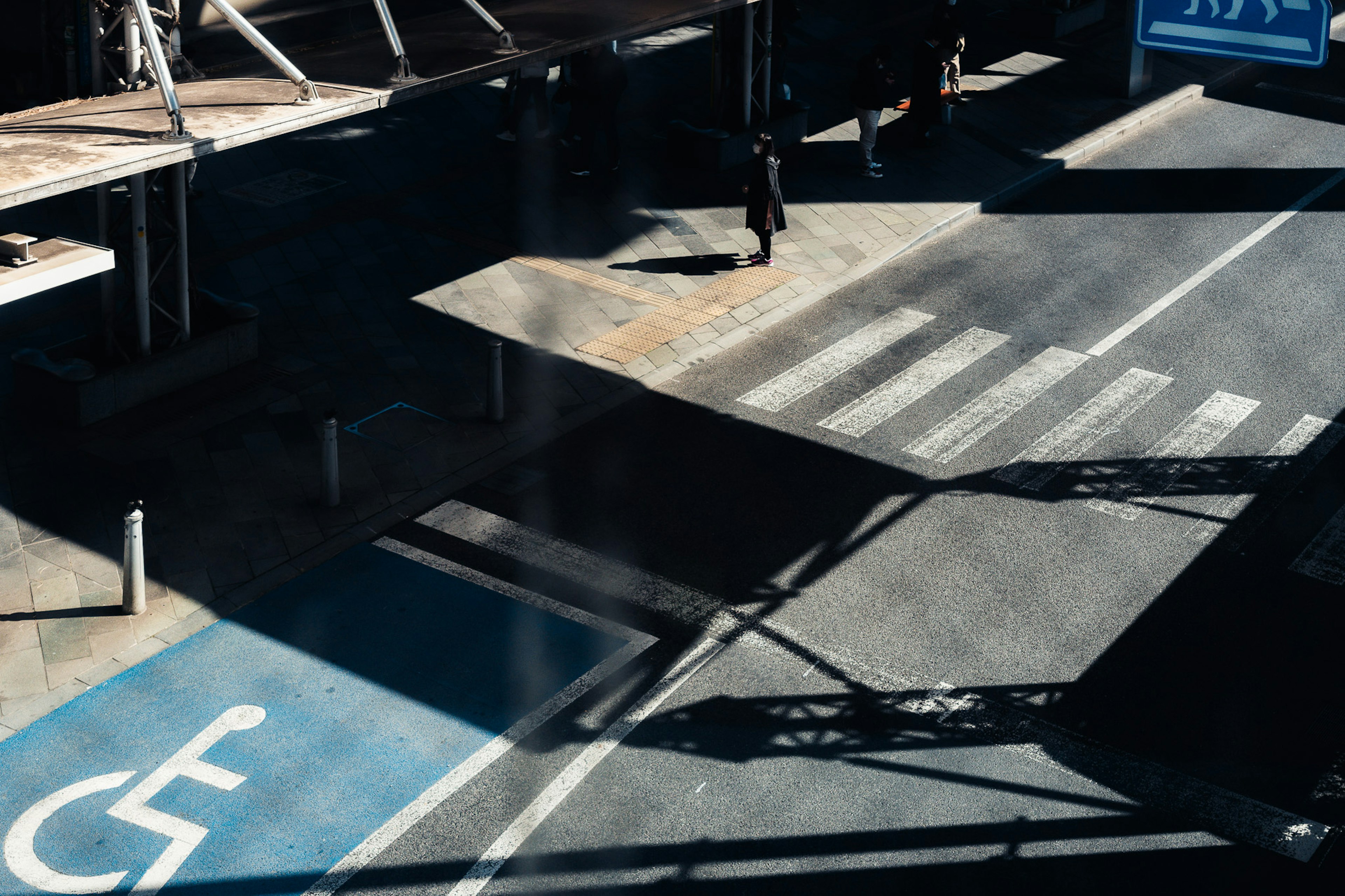 Escena urbana que presenta un espacio de estacionamiento para discapacitados y un paso peatonal desde un punto de vista de intersección