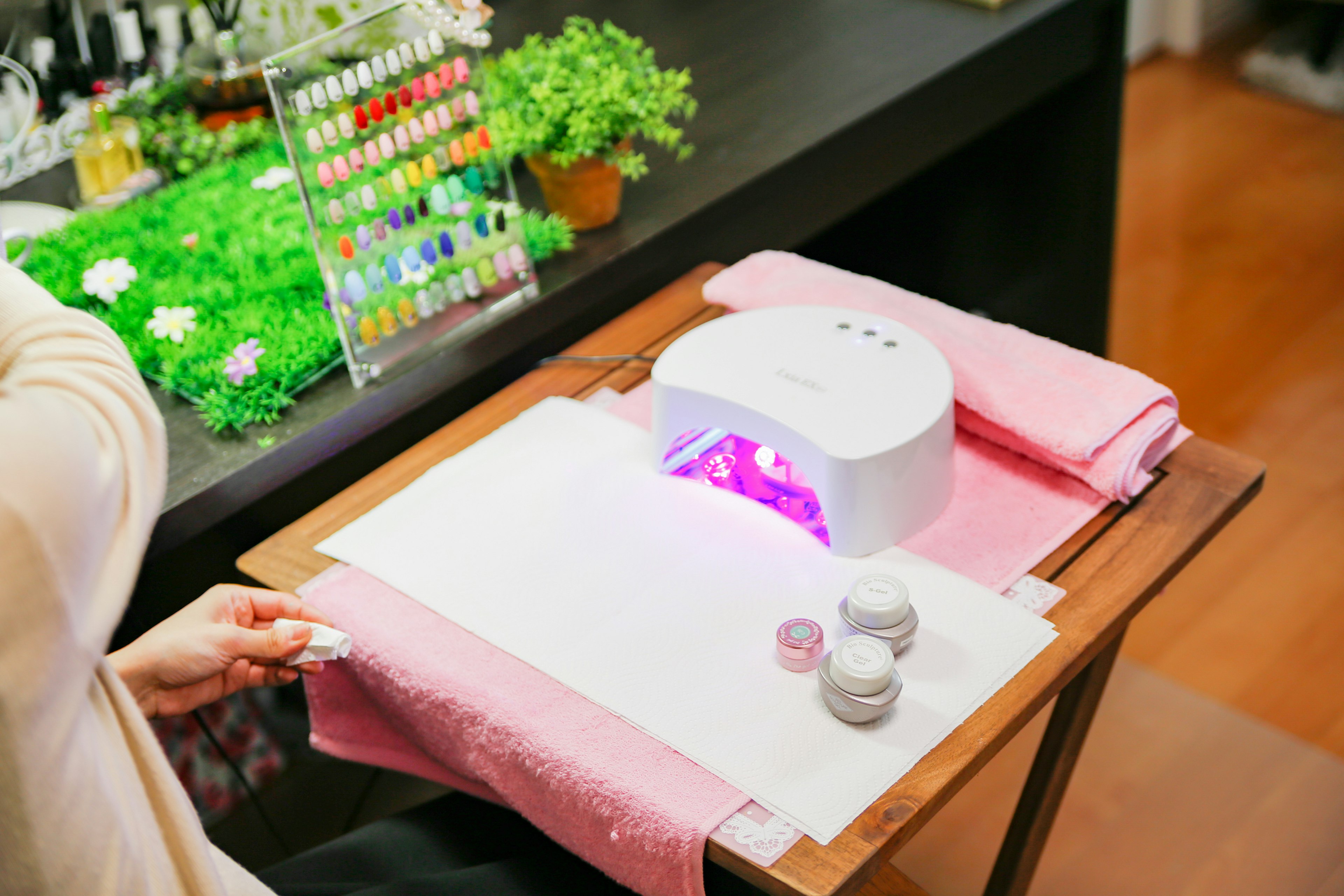 Nail salon table with a nail dryer and colorful nail polish bottles