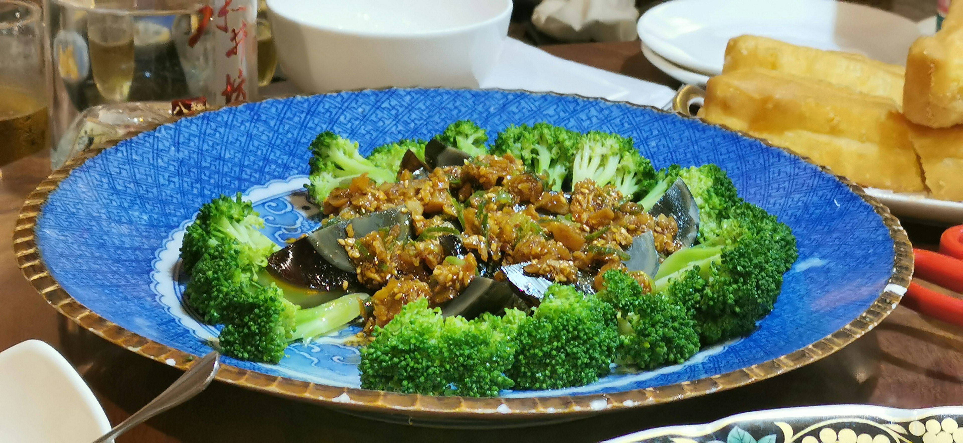 A dish of broccoli and ingredients served on a blue plate