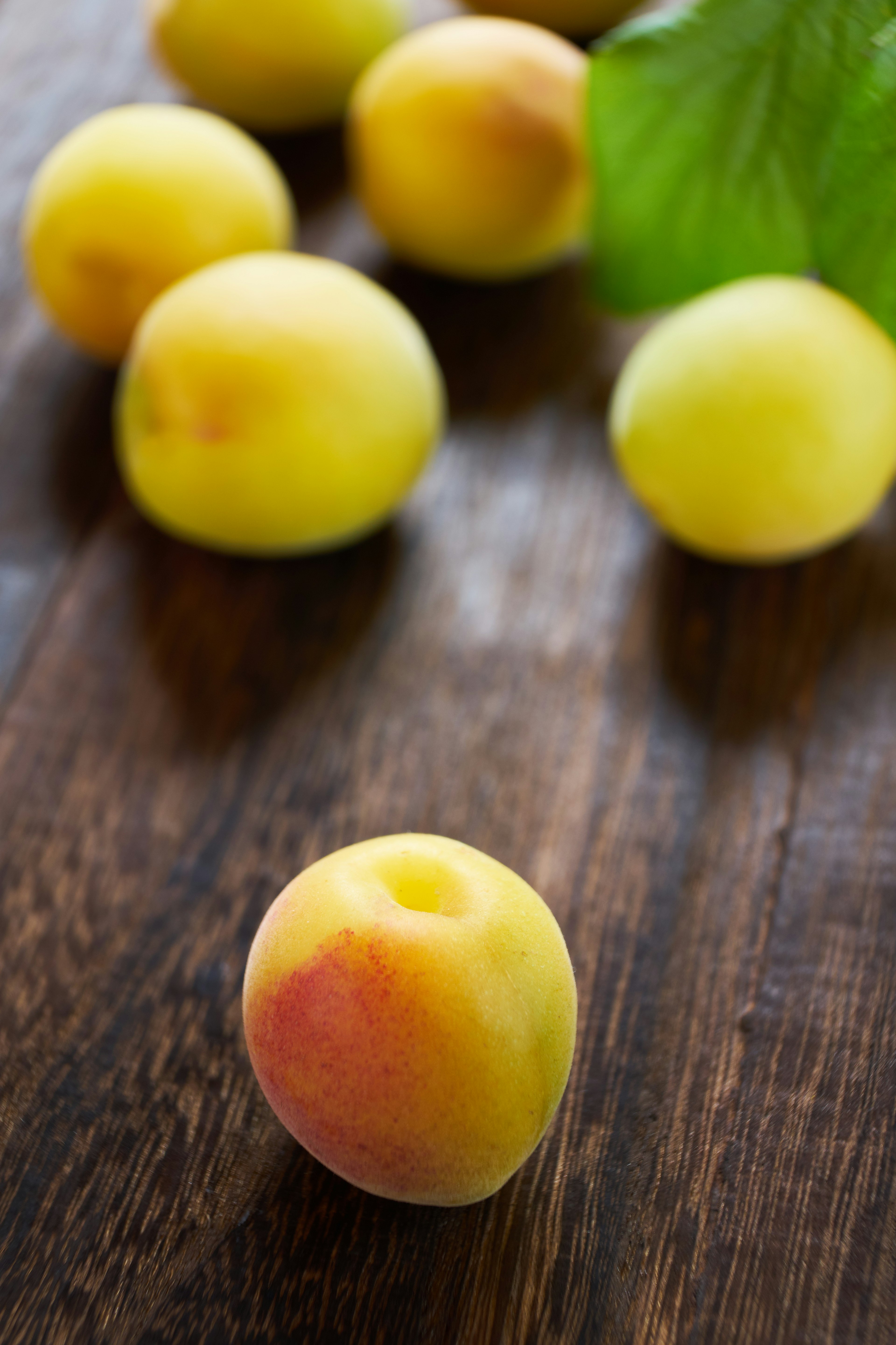 Several yellow peaches placed on a wooden table