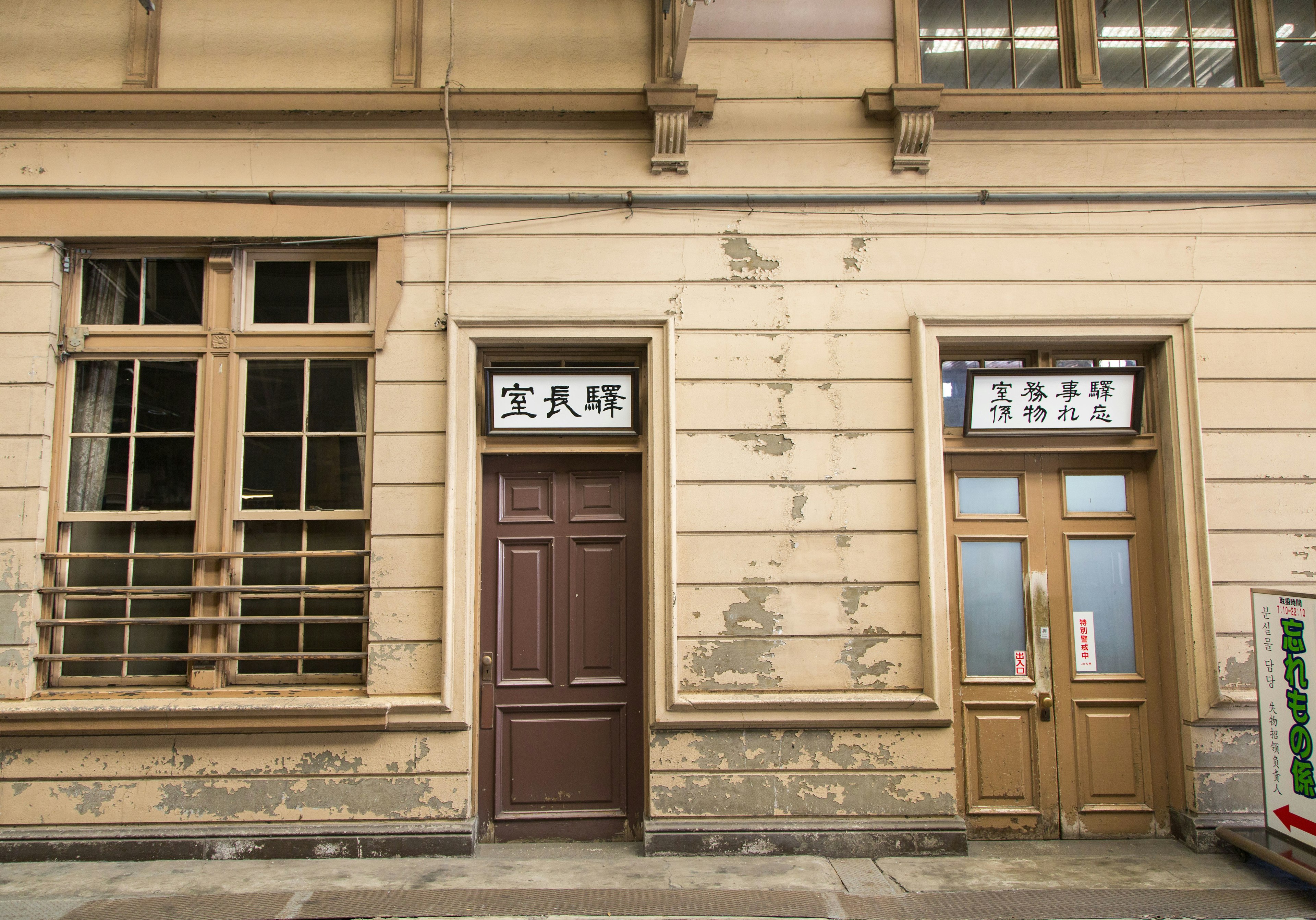 Facade of an old building featuring two doors and a window