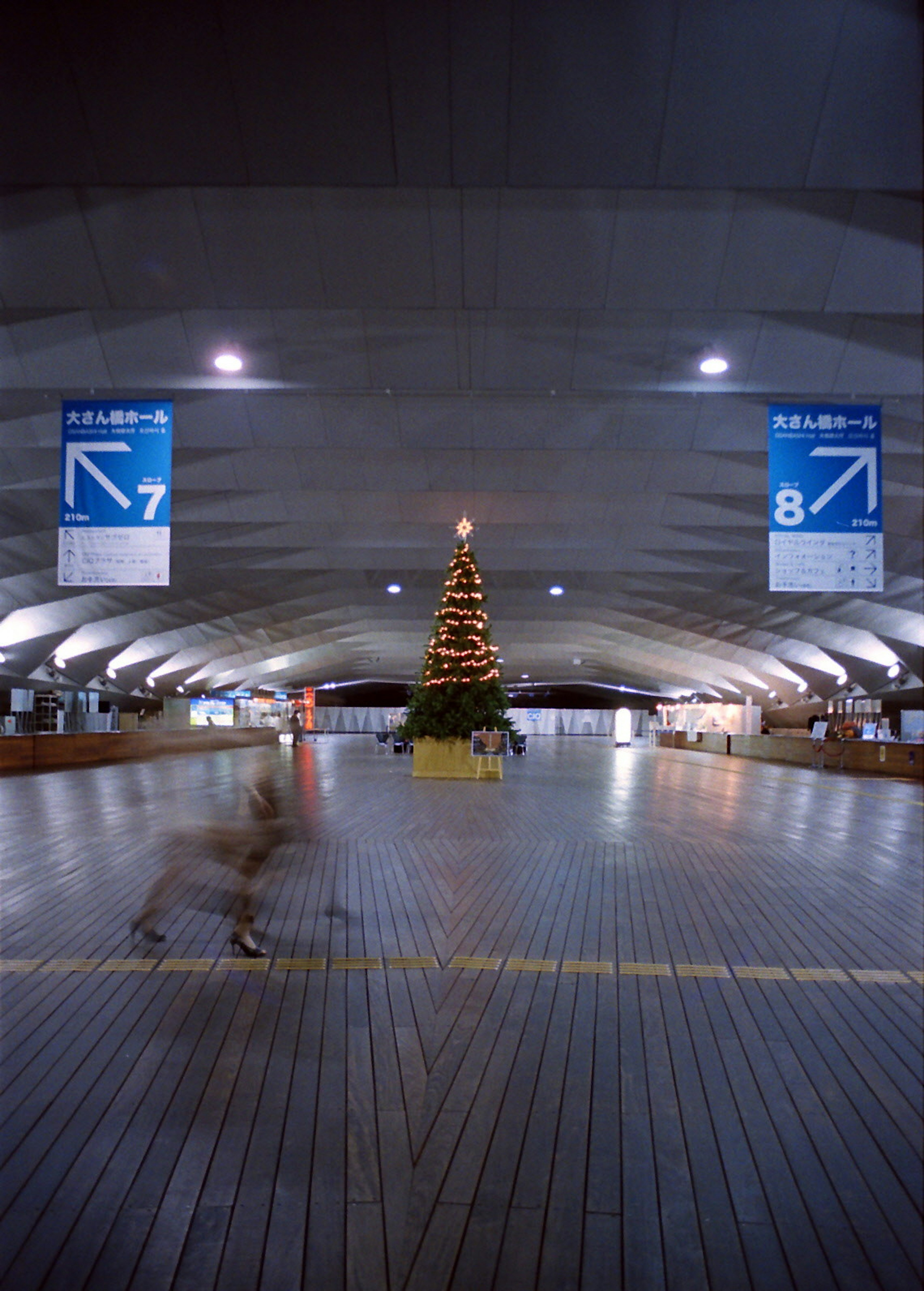 Intérieur spacieux d'une gare avec un sapin de Noël au centre