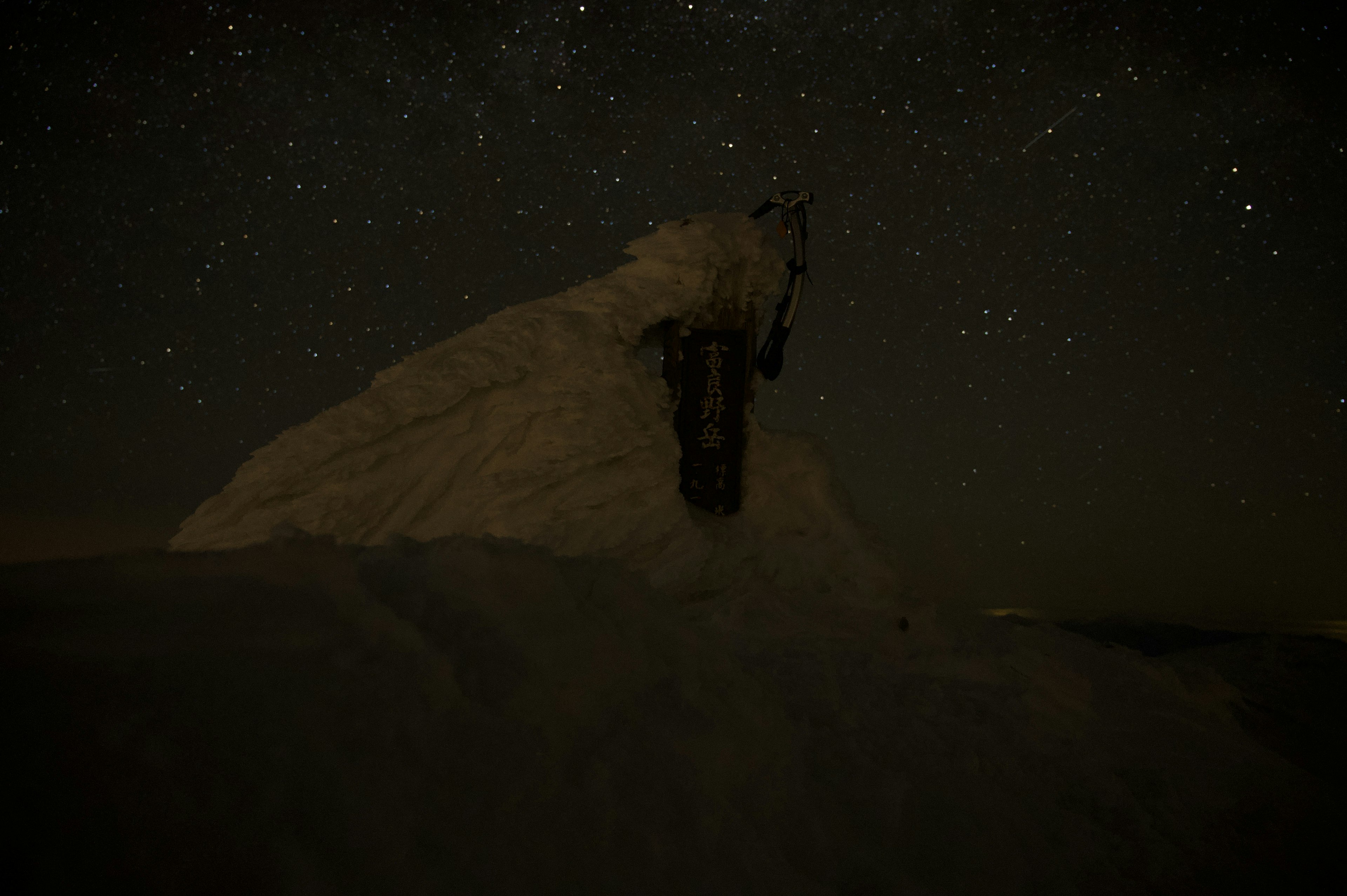 星空の下にある雪に覆われた山のシルエット