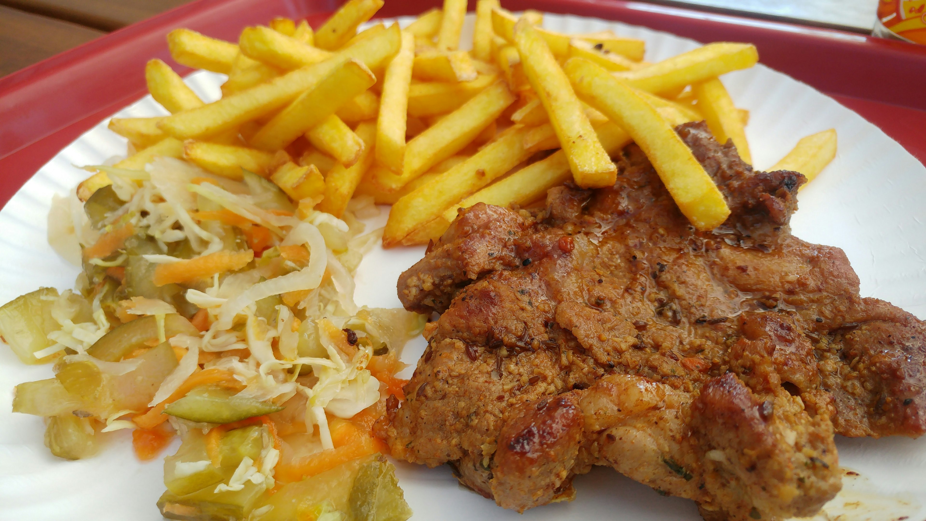 Plato de pollo picante servido con papas fritas y ensalada