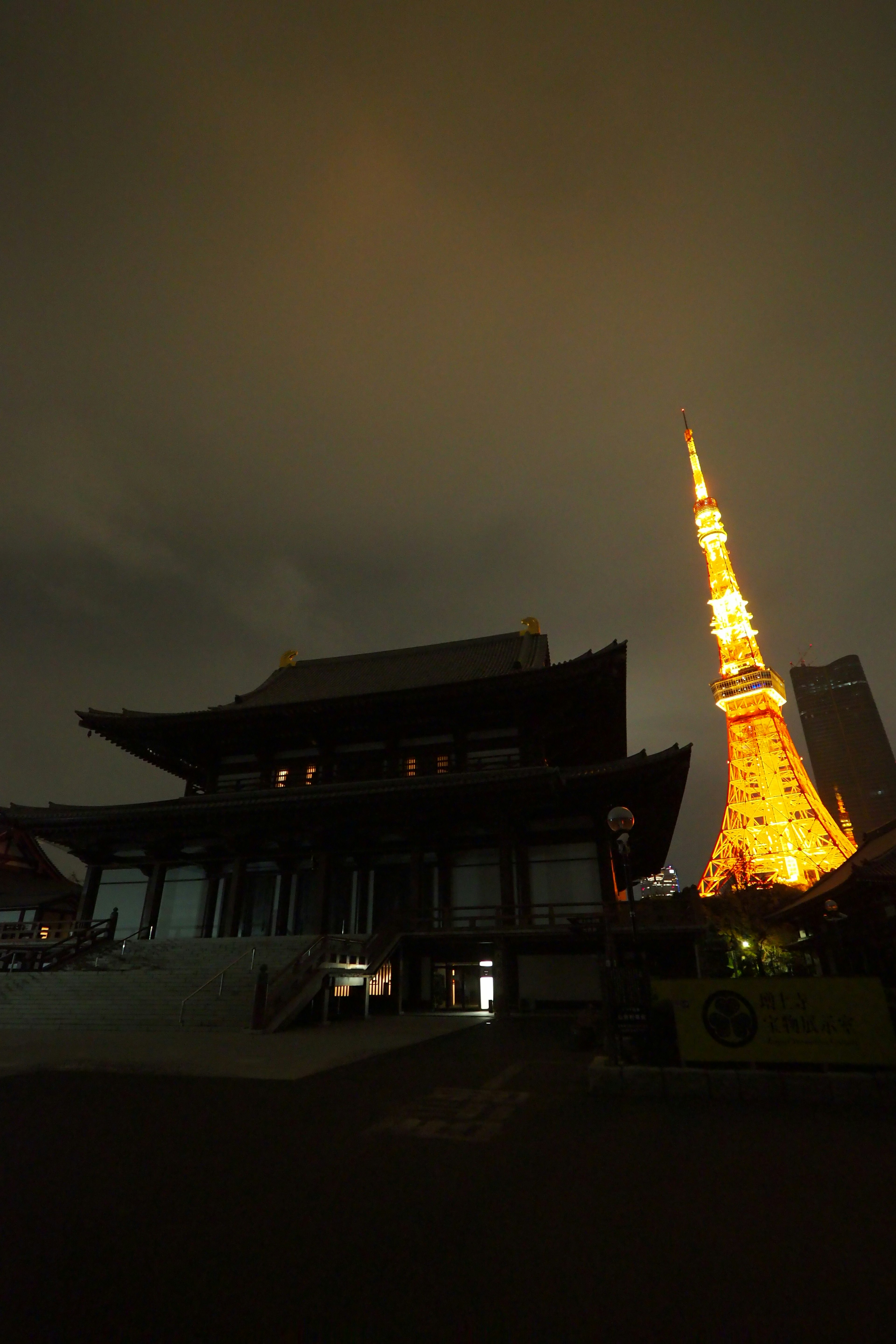 Vue nocturne de la Tokyo Tower et d'un bâtiment traditionnel