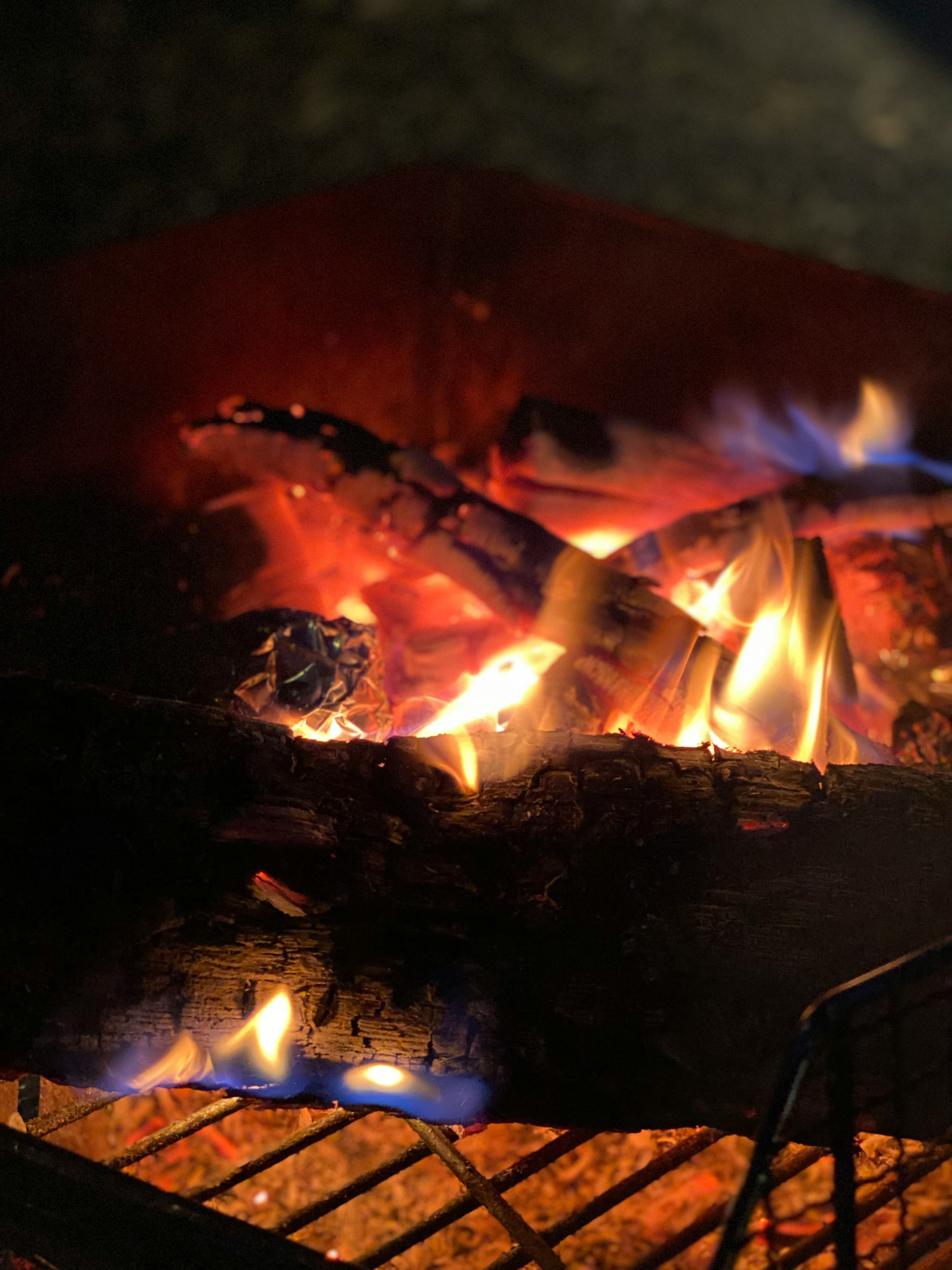 Nahaufnahme brennender Holzscheite in einem Lagerfeuer mit lebhaften Flammen