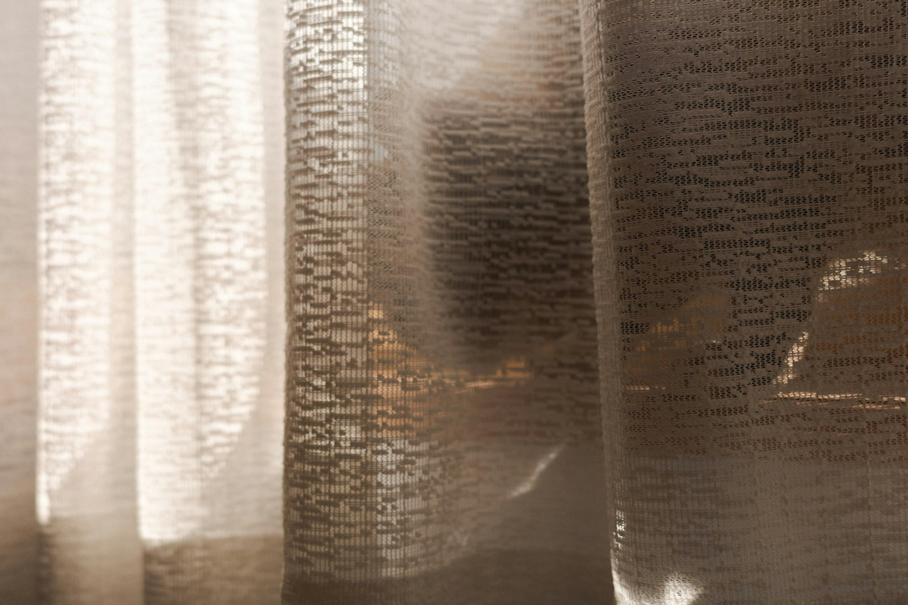 Soft light and shadow patterns visible through sheer curtains