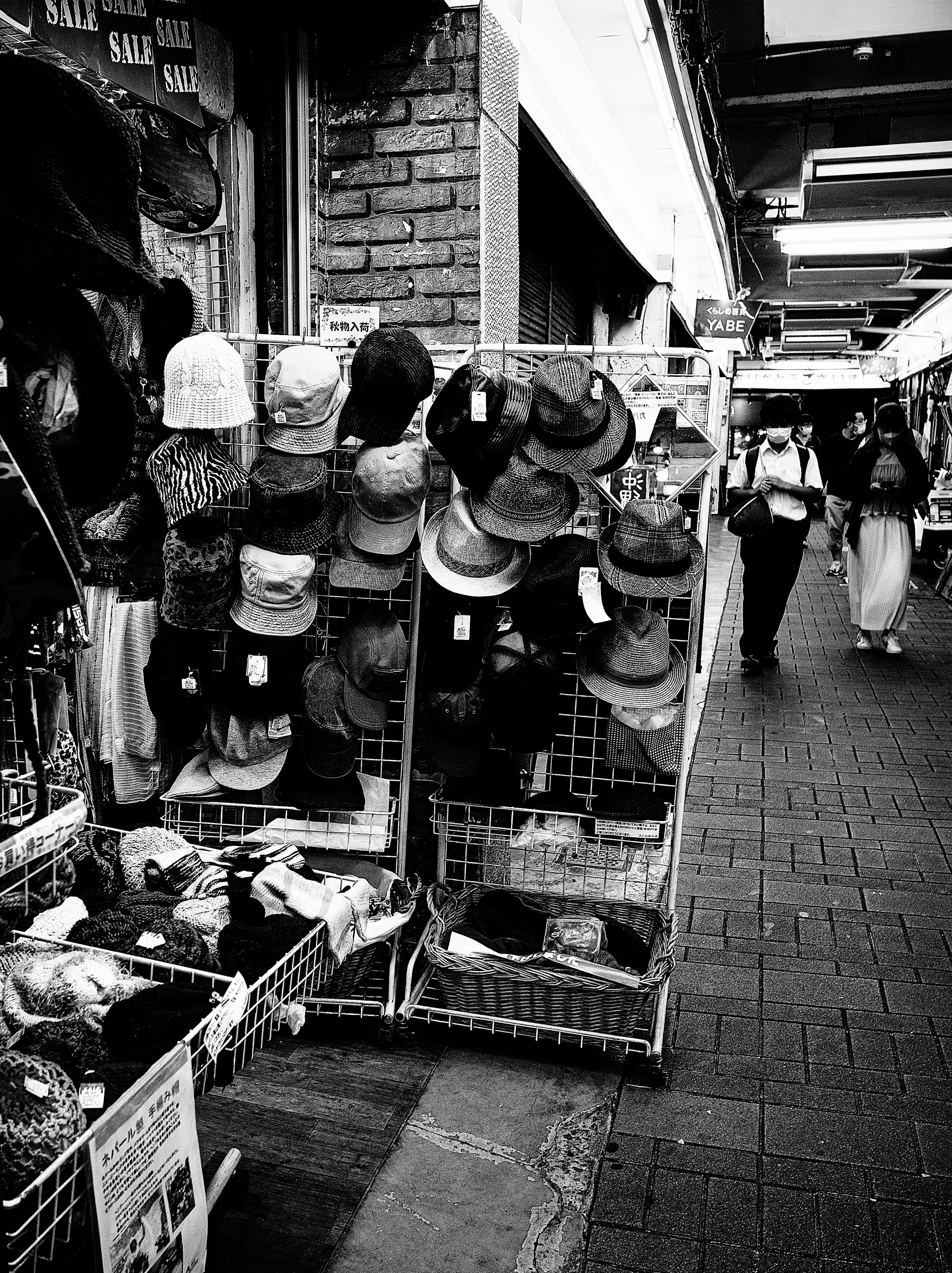 Escena en blanco y negro de un puesto con varios sombreros expuestos