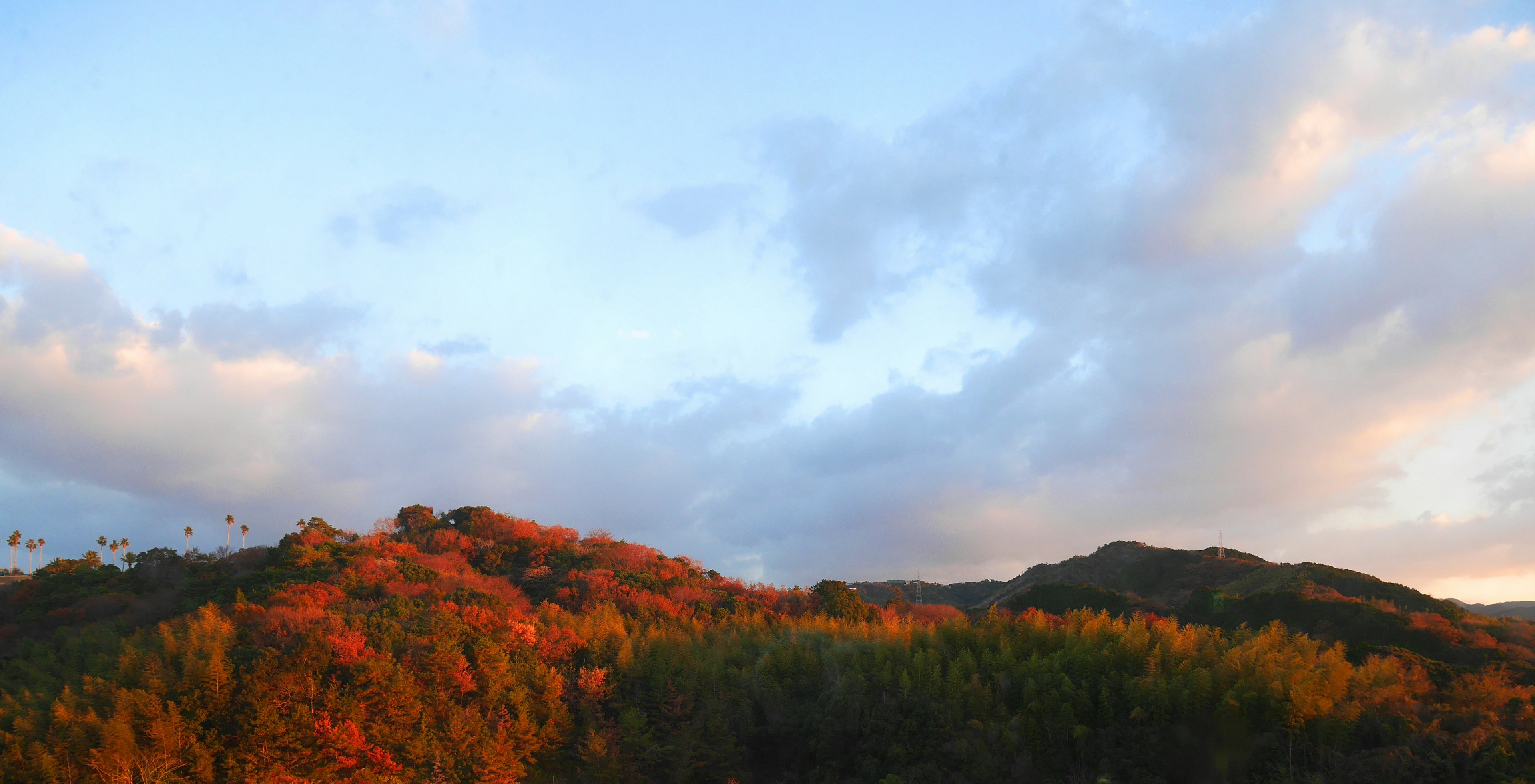 Montagne illuminate dal tramonto con nuvole colorate