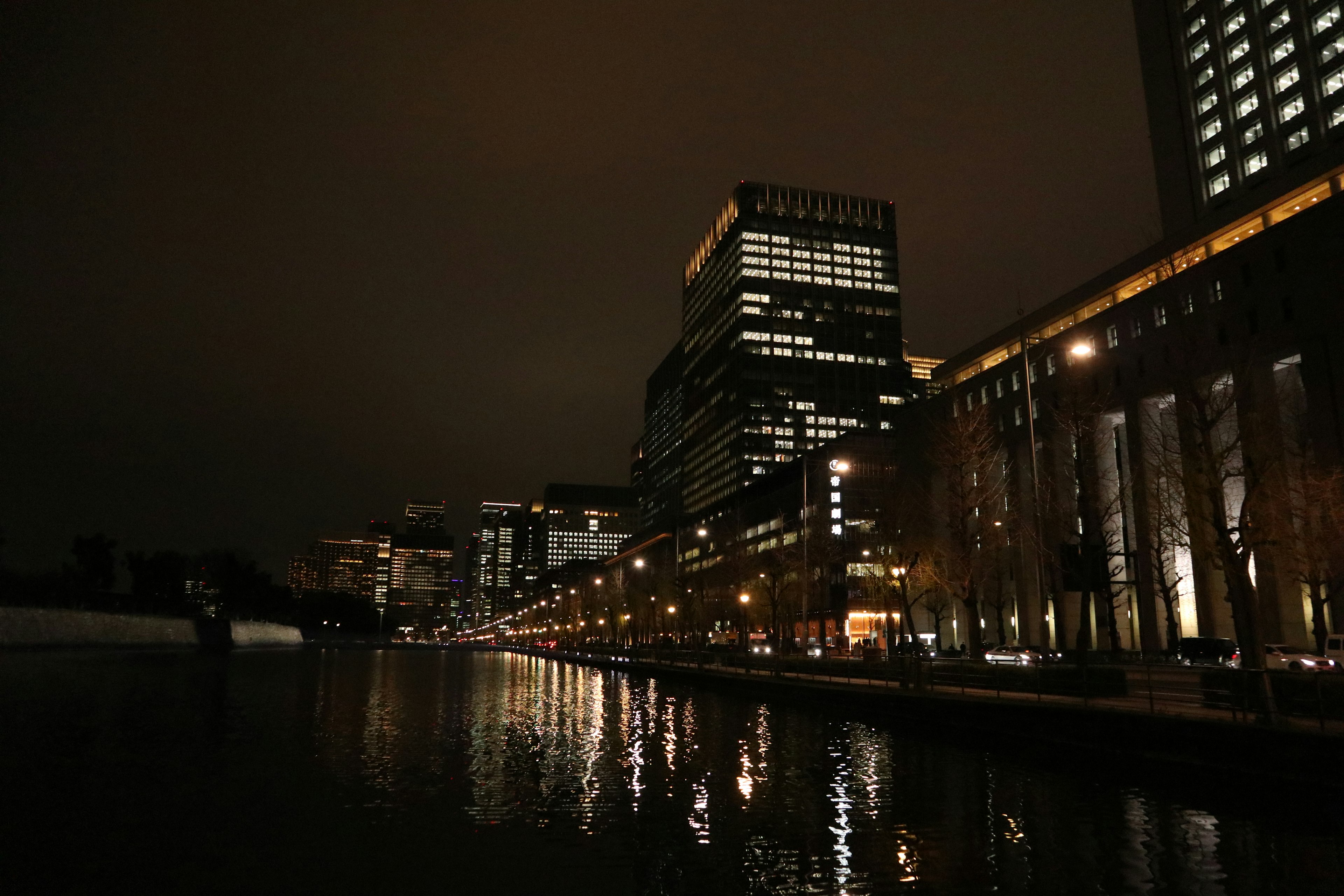 Paesaggio urbano notturno con edifici che si riflettono sull'acqua