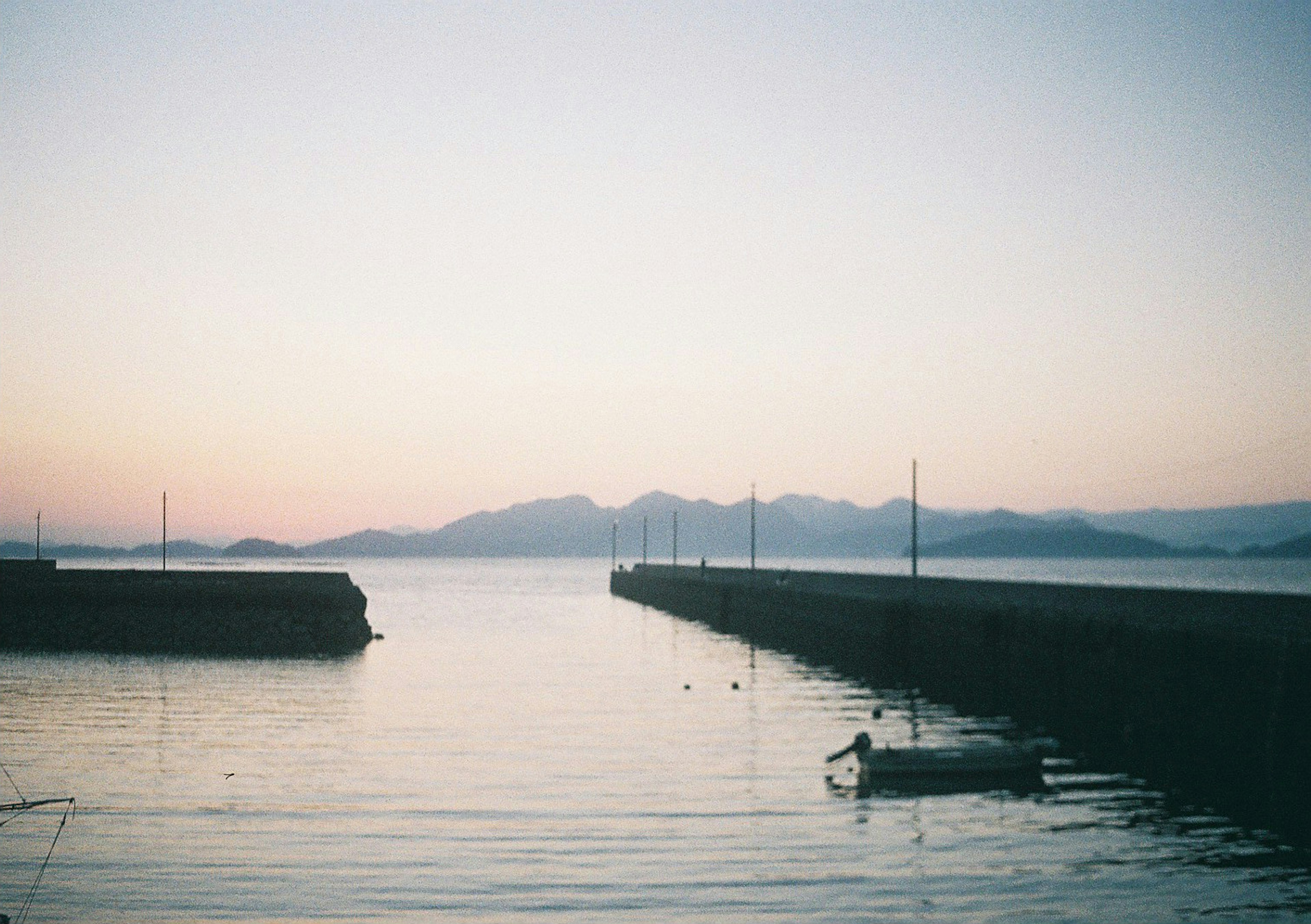 Eine ruhige Szene mit einem kleinen Boot auf ruhigem Wasser während des Sonnenuntergangs