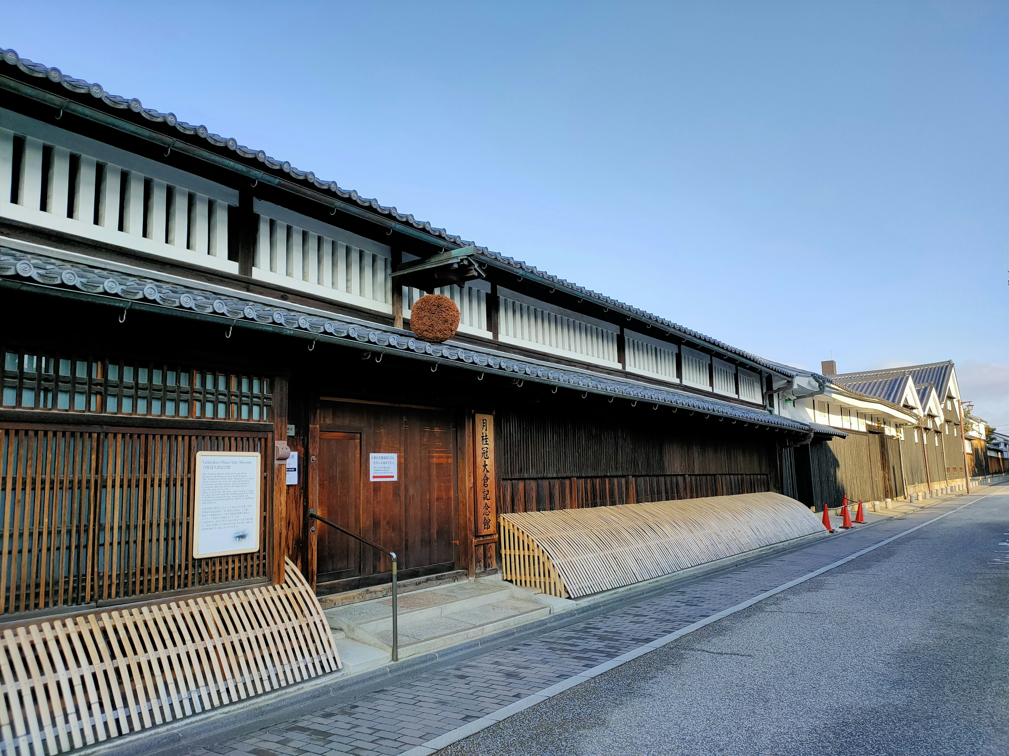 Äußere eines traditionellen japanischen Gebäudes mit Holztüren und markantem Dach in einer ruhigen Straße