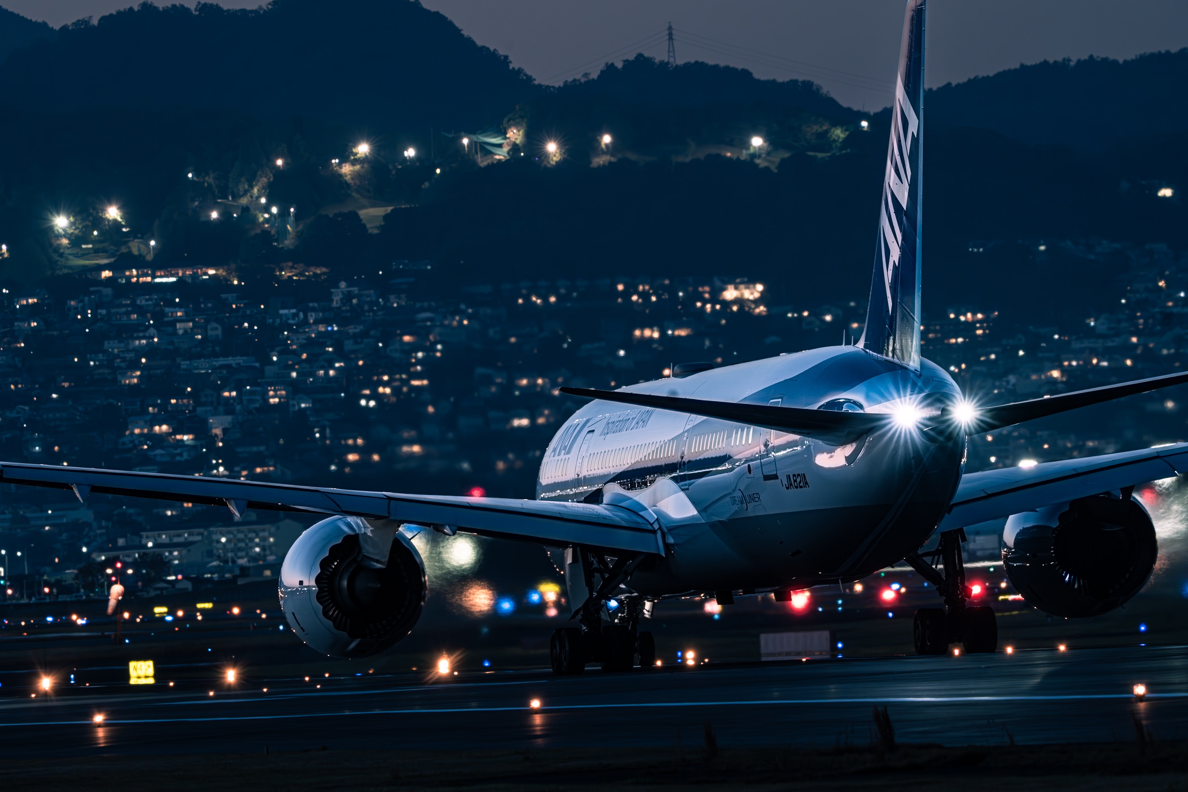 Imagen de un avión aterrizando en una pista por la noche