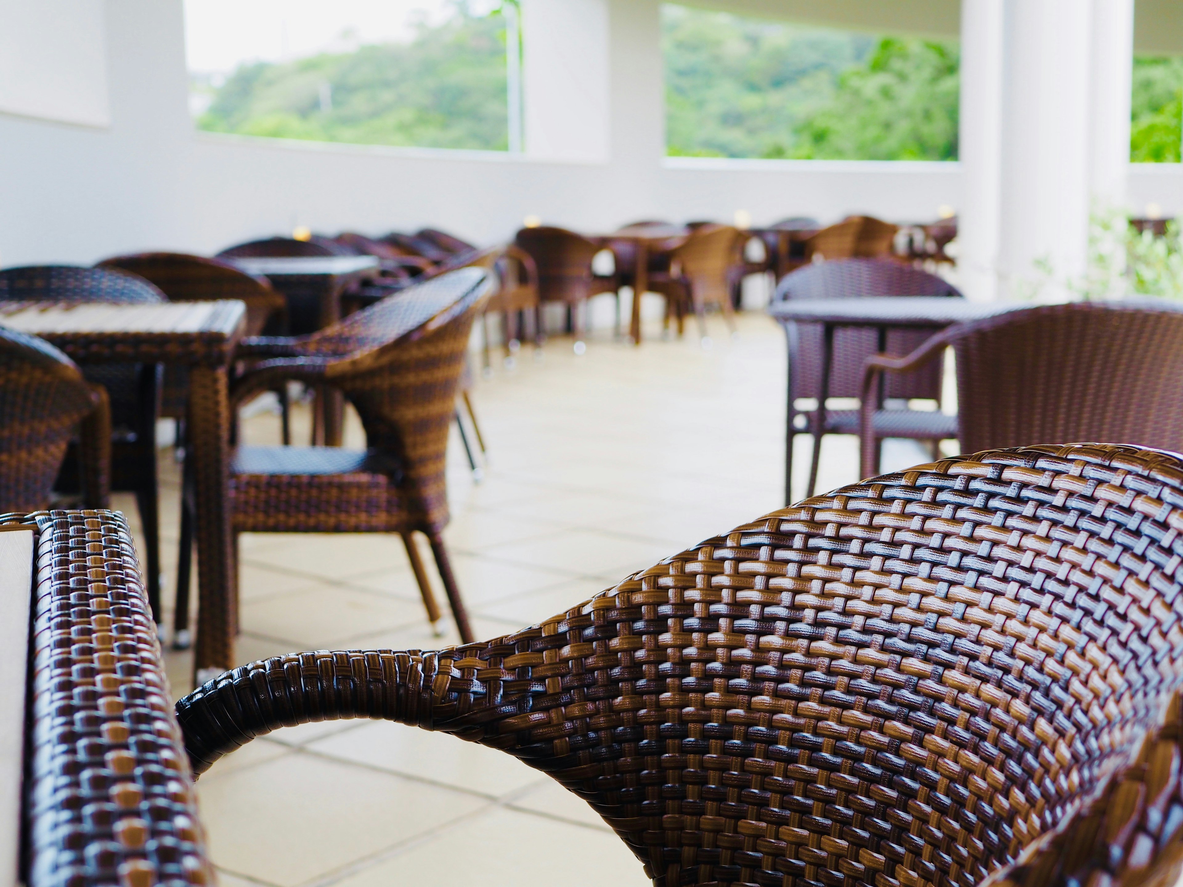 Terrasse de café extérieure avec des chaises et des tables en osier