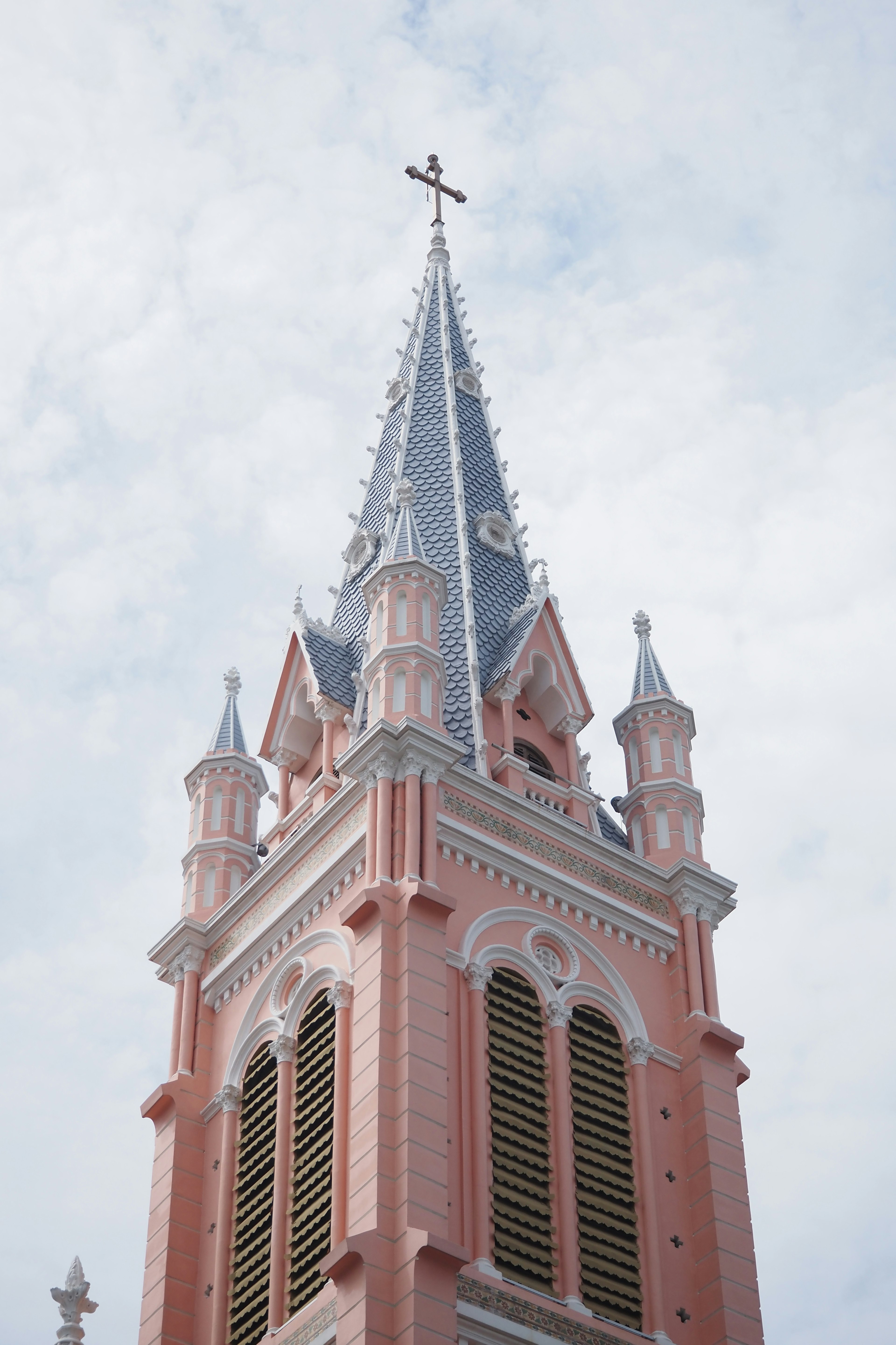 Flèche d'église avec tour rose et toit bleu