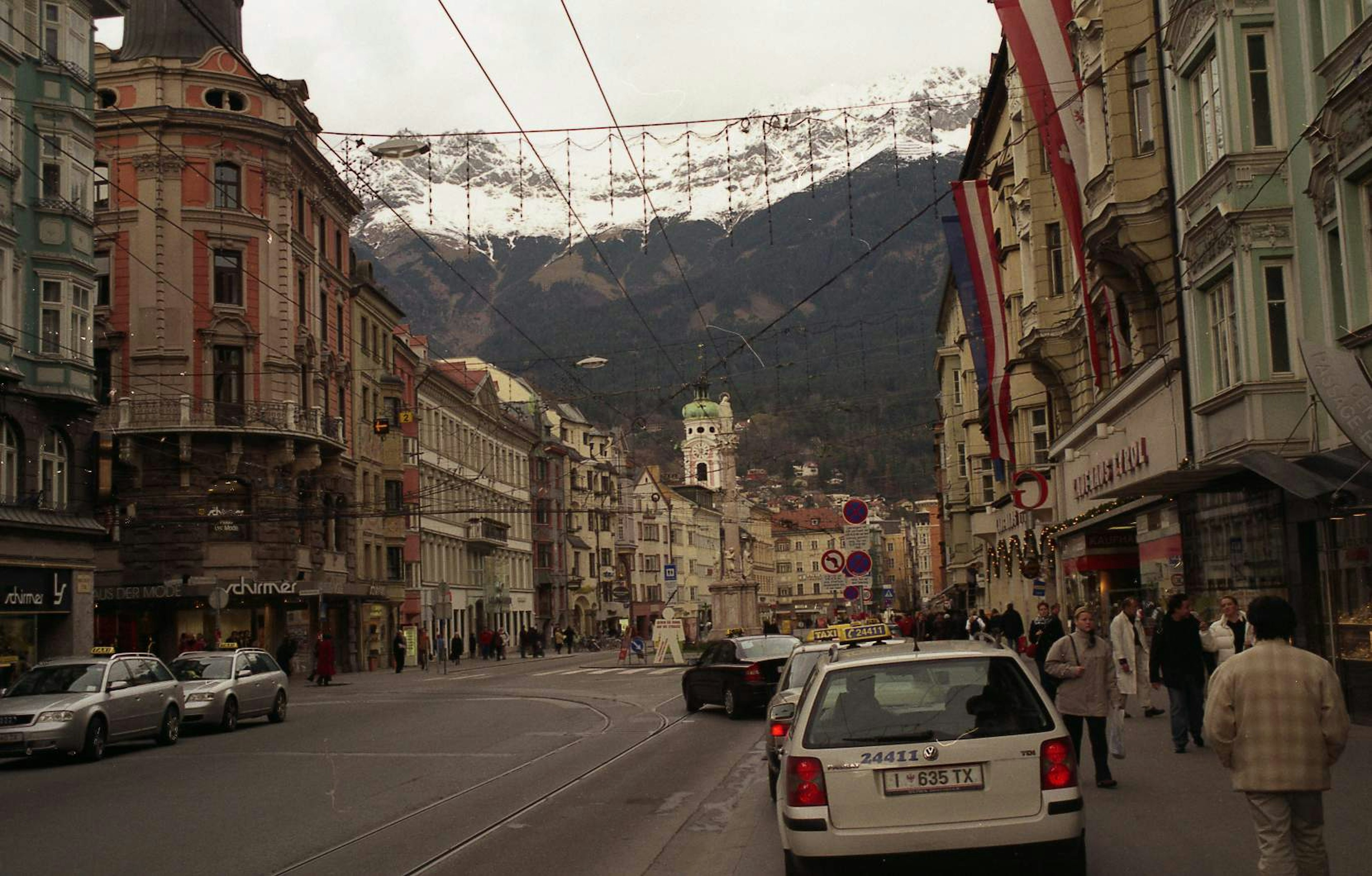 Vue de rue avec des bâtiments historiques et des montagnes enneigées