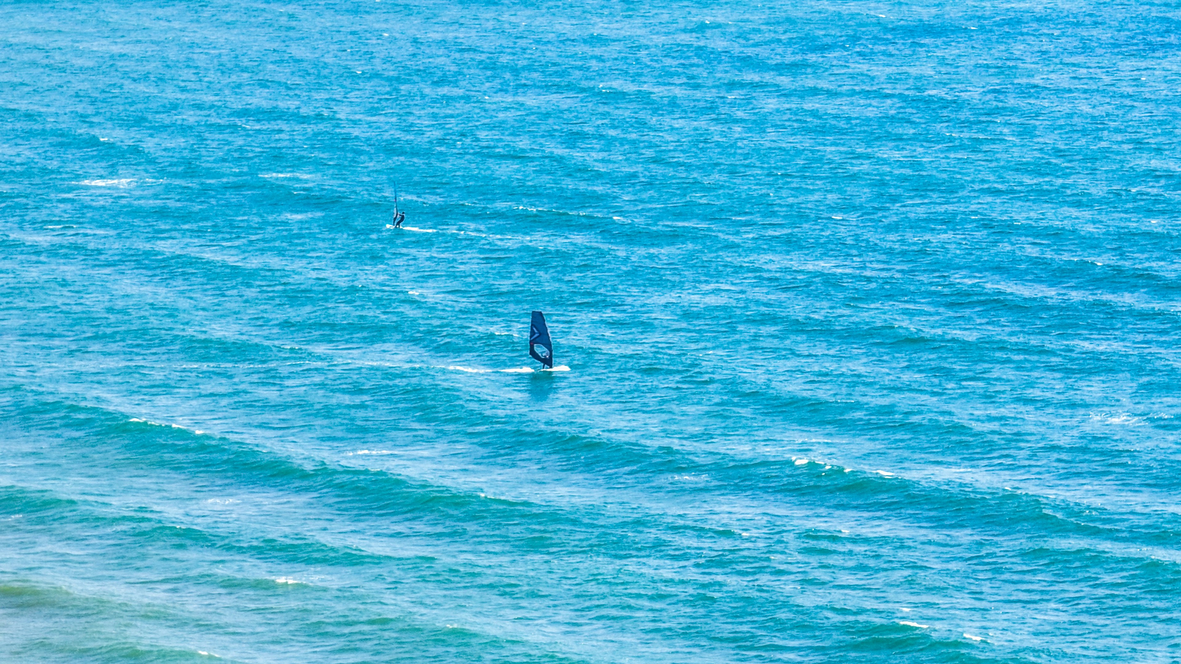 Ein Segelboot auf einem blauen Ozean mit sanften Wellen