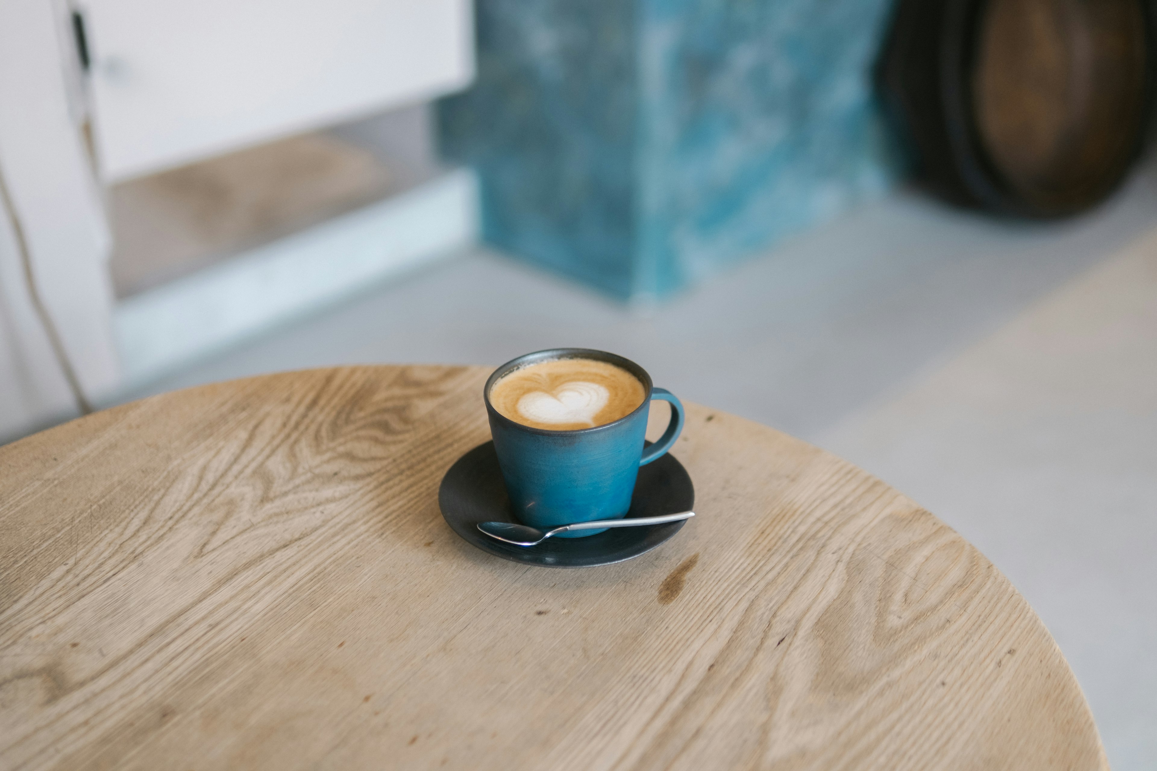 Un café latte avec de l'art sur le dessus dans une tasse bleue sur une table en bois