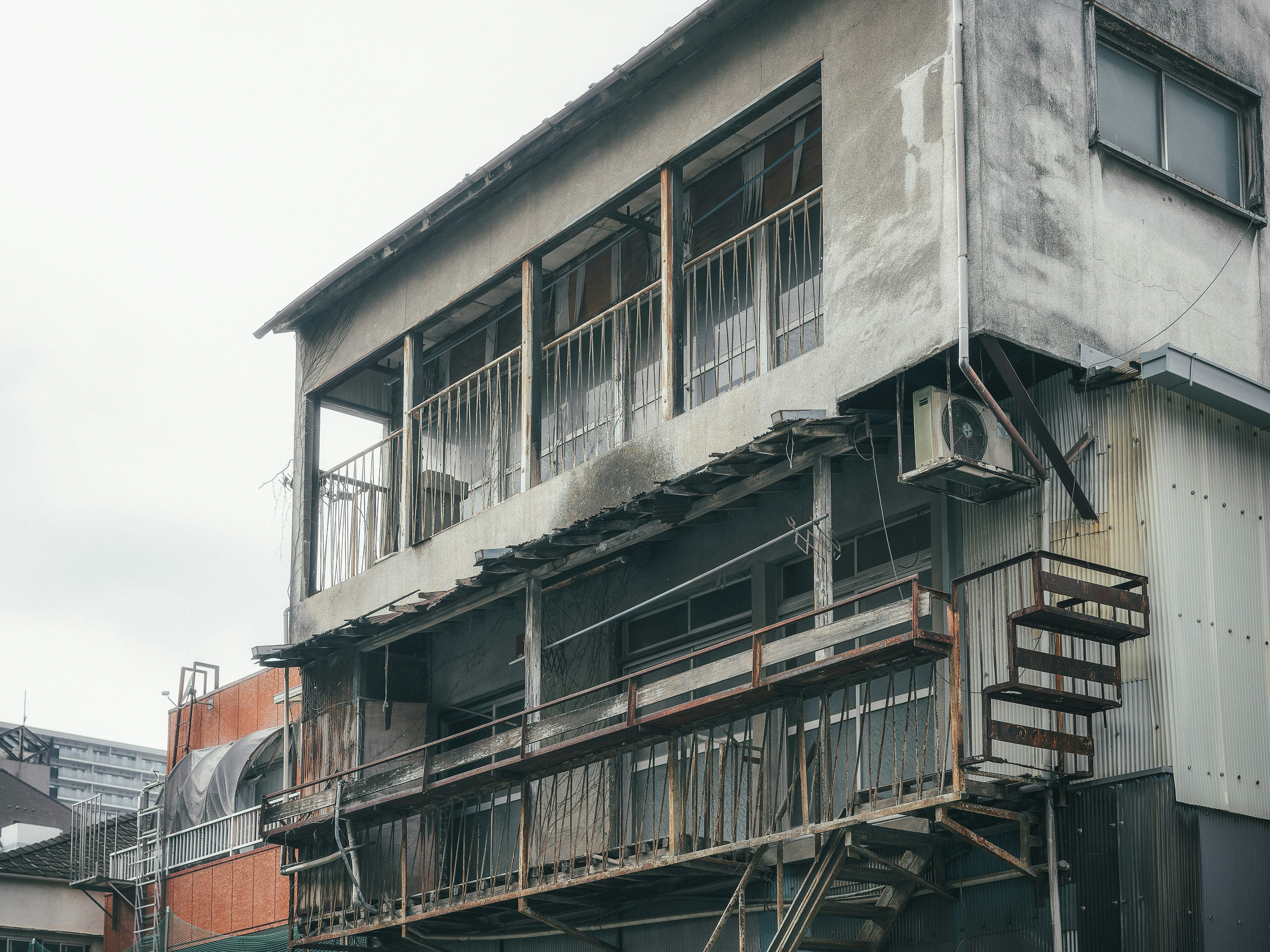 Exterior de un edificio antiguo con balcones y una escalera