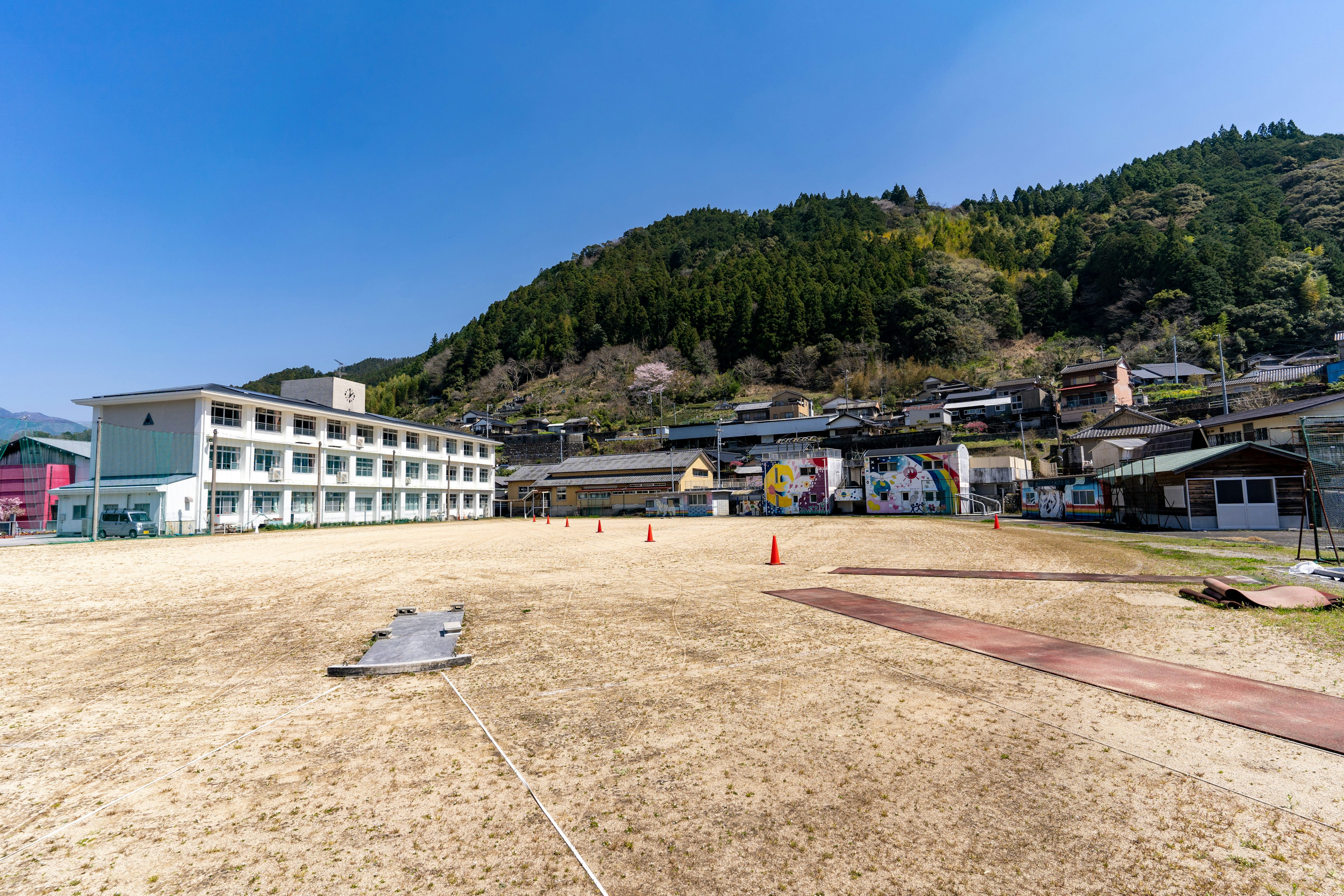 Ein Schulspielplatz unter einem klaren blauen Himmel mit umliegenden Gebäuden