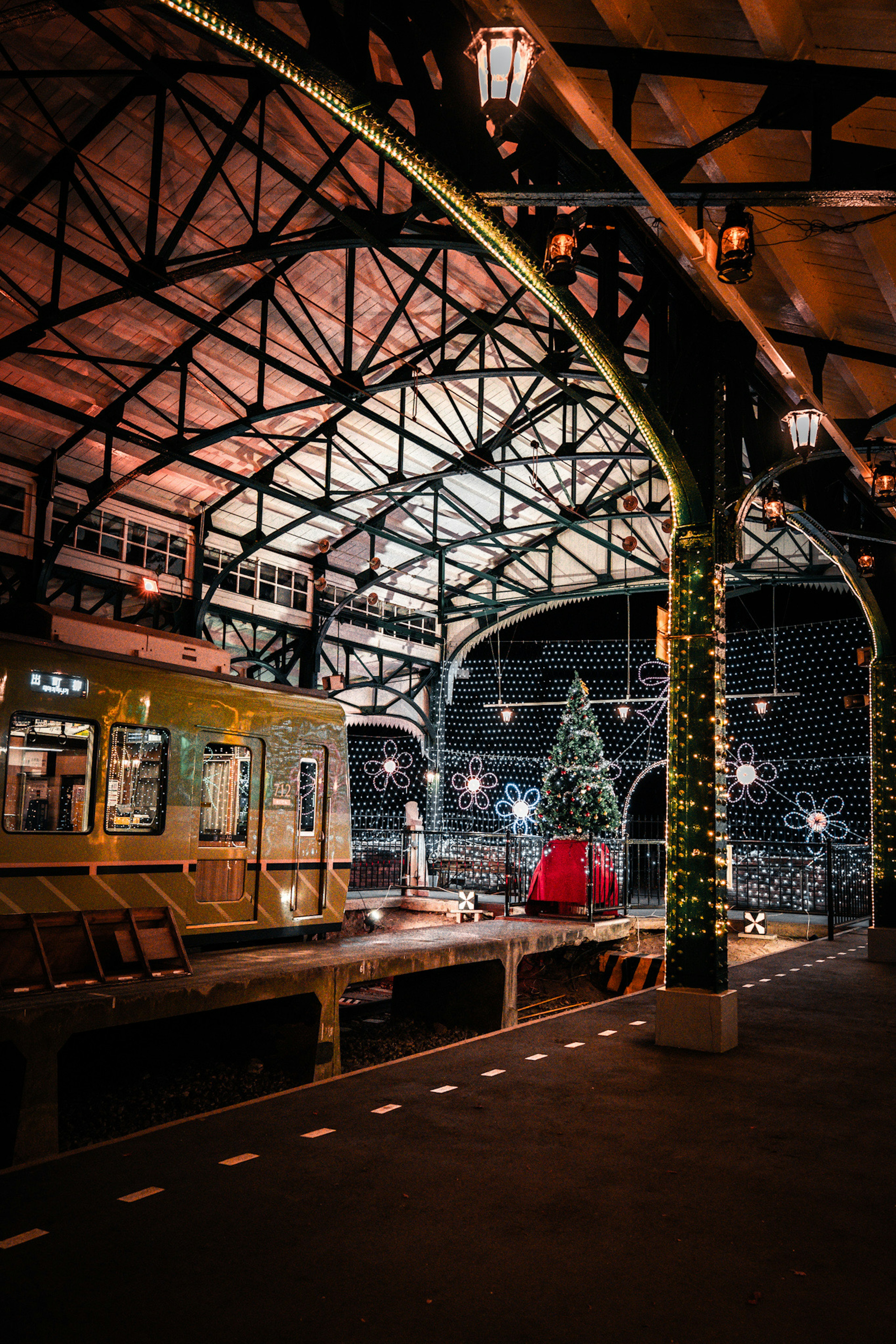 Interior de una estación decorada para Navidad con un árbol de Navidad y un tren vintage