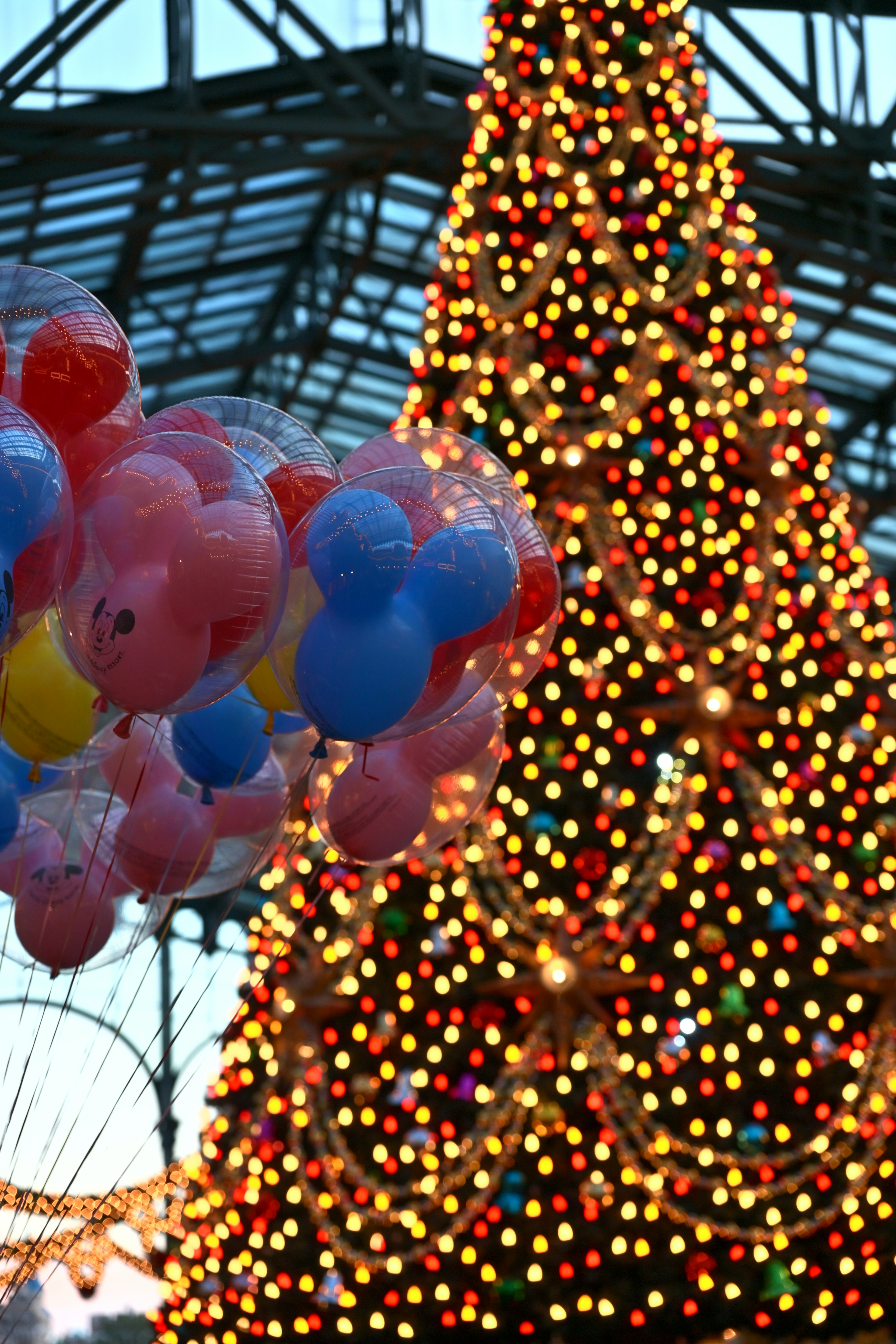 Christmas tree adorned with colorful lights and balloons