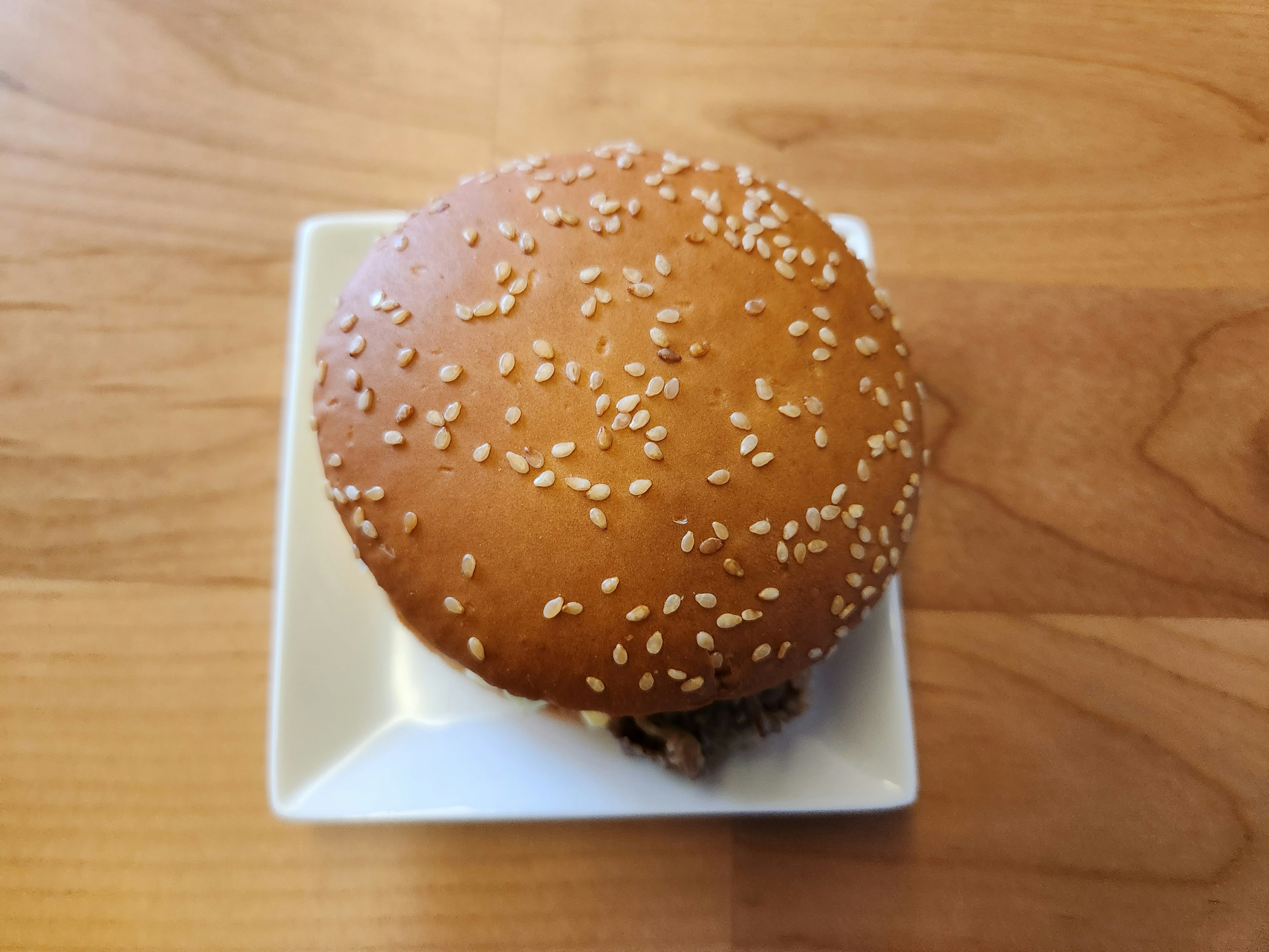 Hamburger mit Sesambrötchen auf einem weißen Teller